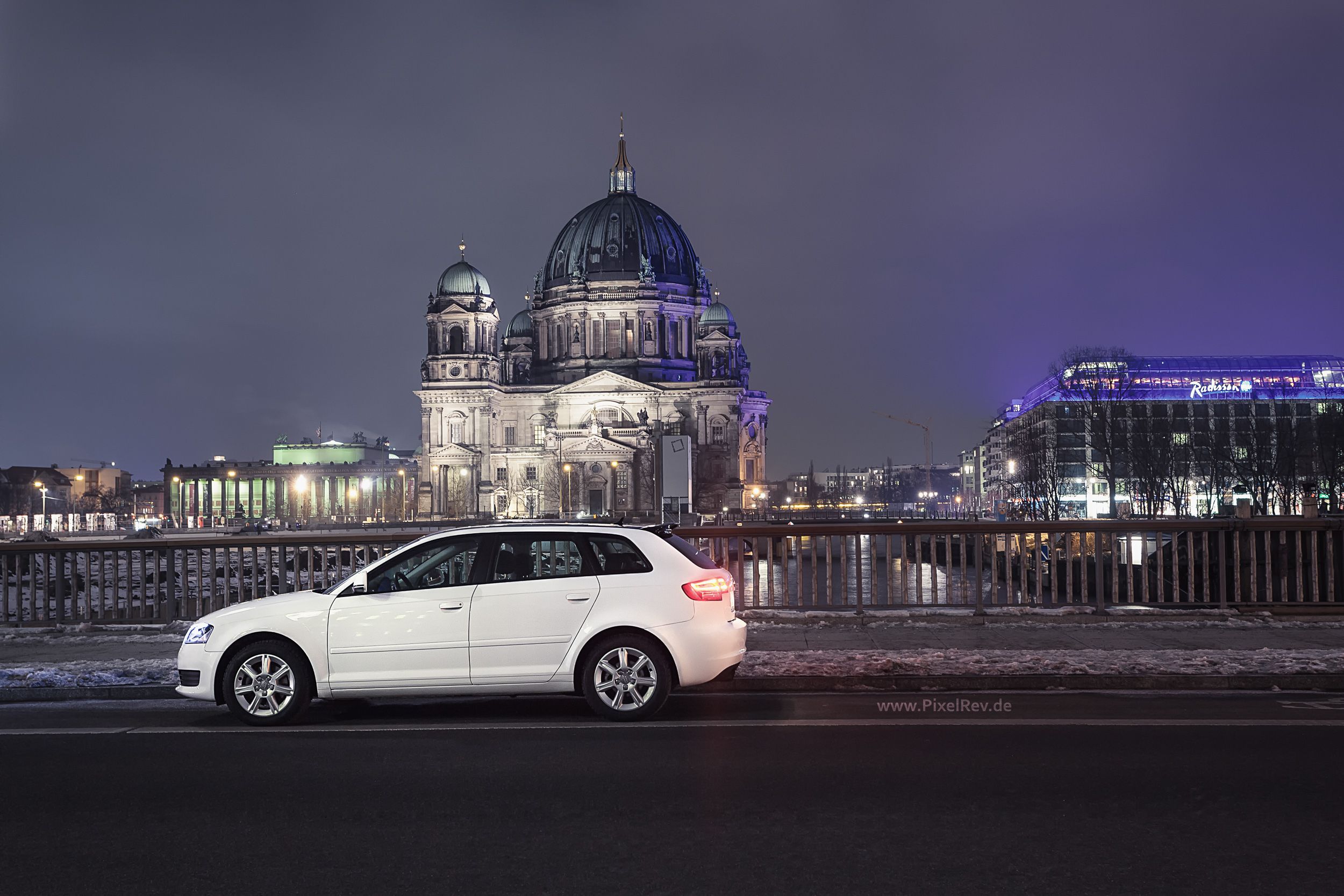 Weißer Audi A3 Sportback nachts vor dem beleuchteten Berliner Dom