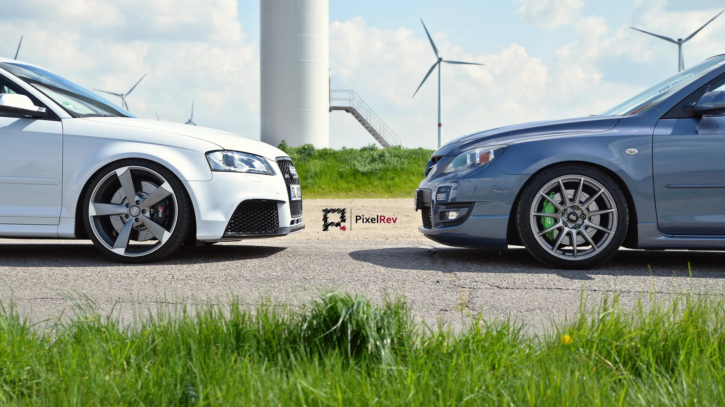 Weißer Audi RS3 und grauer Mazda 3 MPS vor Windrädern in Brandenburg