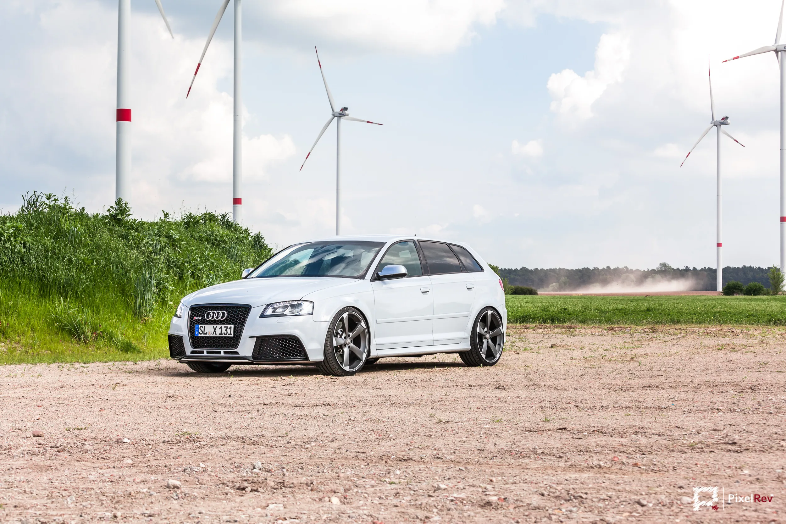 Front des weißen Audi RS3 Sportback vor Windrädern