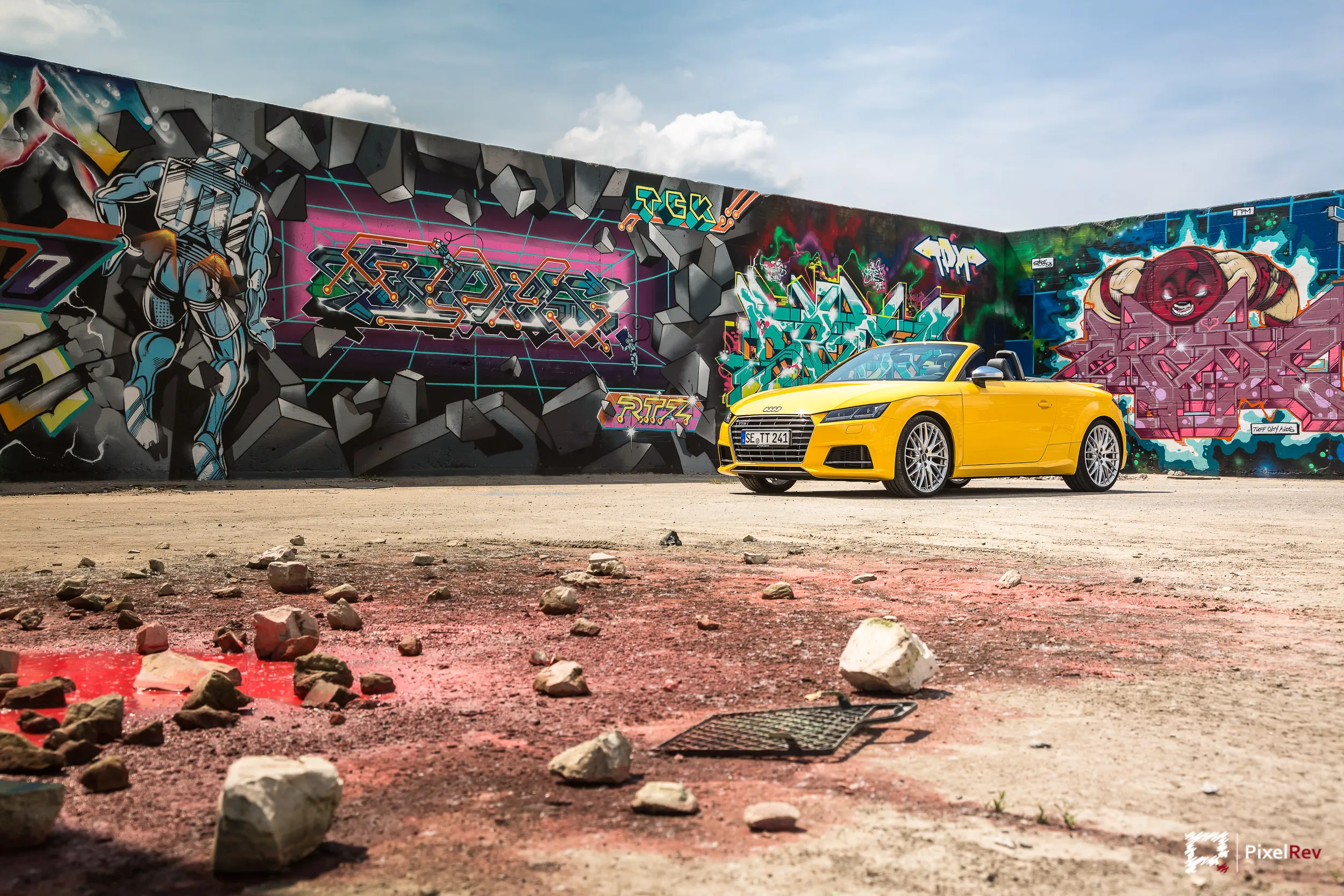 Gelber Audi TTS Roadster vor einer großen Graffitiwand in Berlin