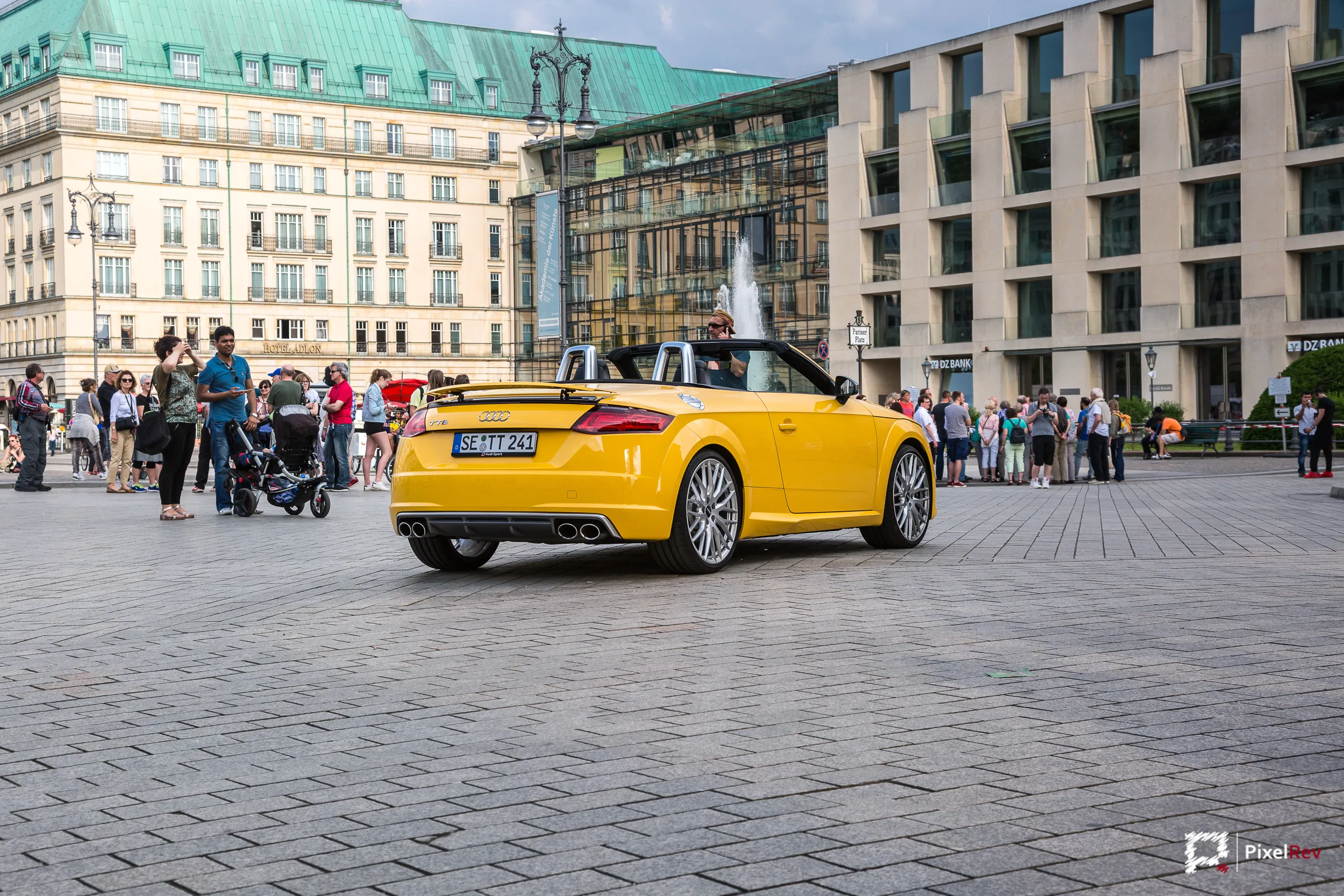 Gelber Audi TTS Roadster am Pariser Platz in Berlin, umgeben von Passanten