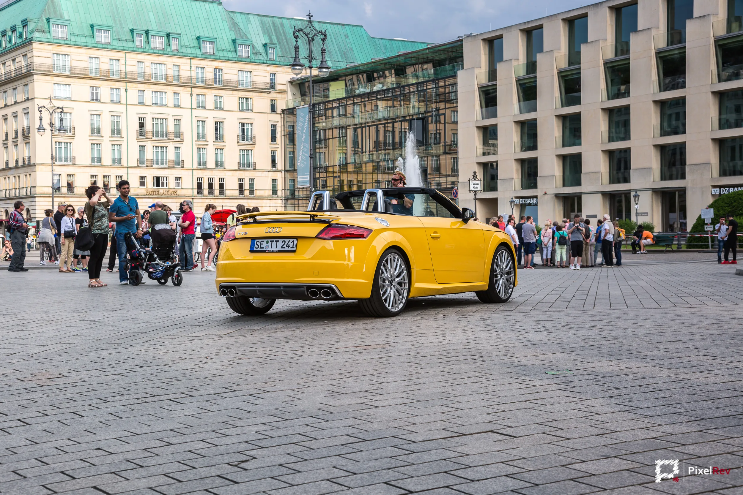 Gelber Audi TTS Roadster am Pariser Platz in Berlin, umgeben von Passanten