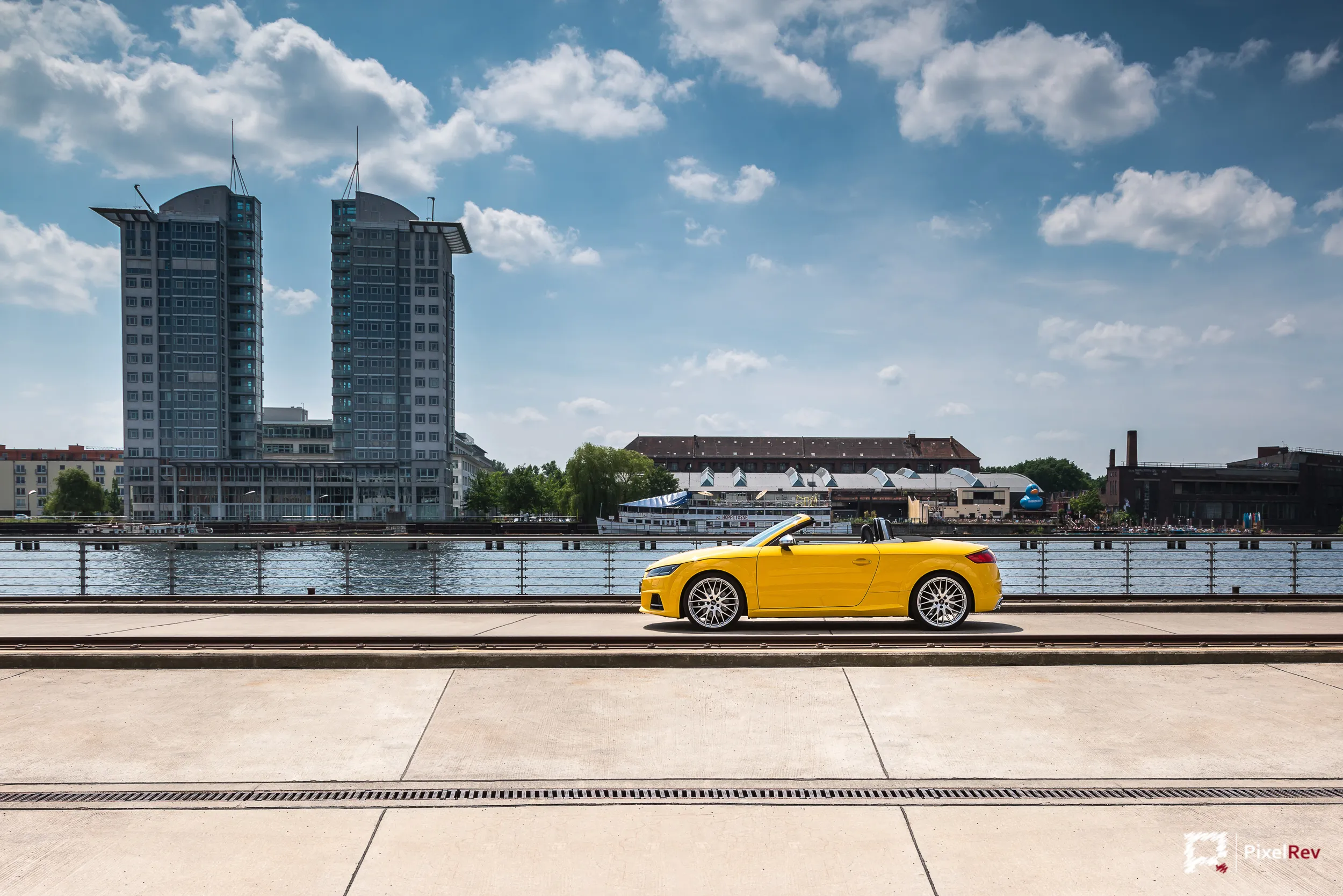 Gelber Audi TTS Roadster an der Spree vor den Treptowers in Berlin