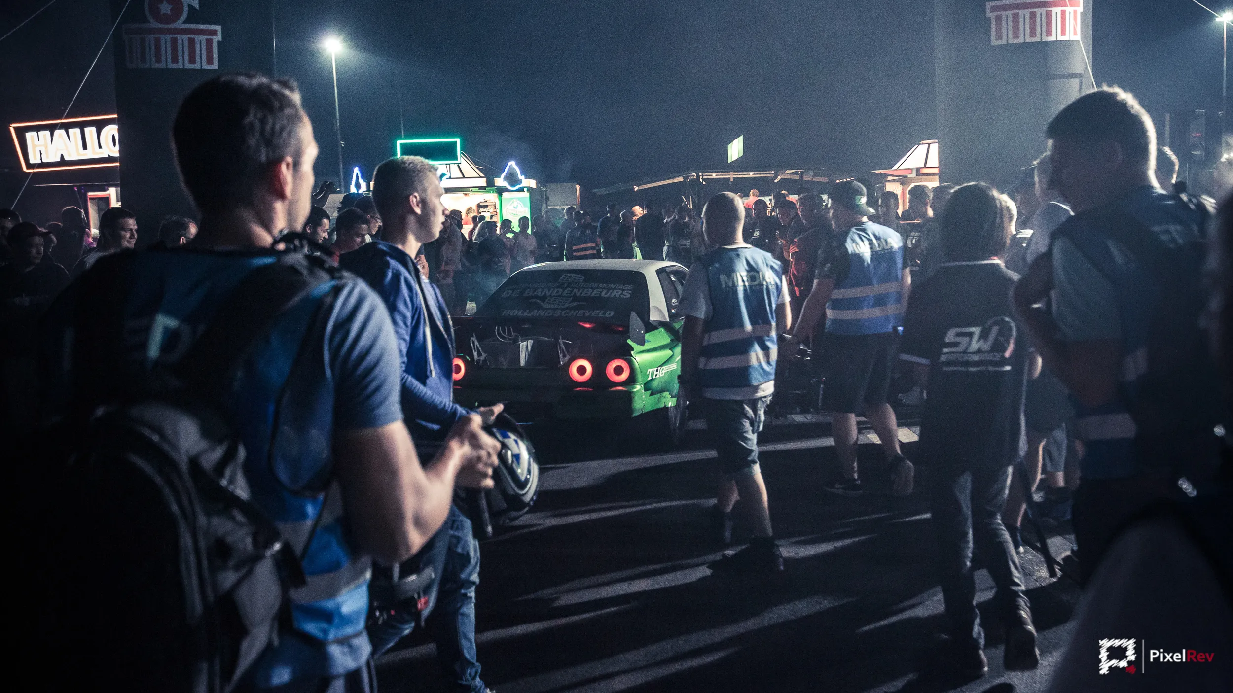 Besucher drängen sich nachts um einen Nissan Skyline beim Reisbrennen 2017