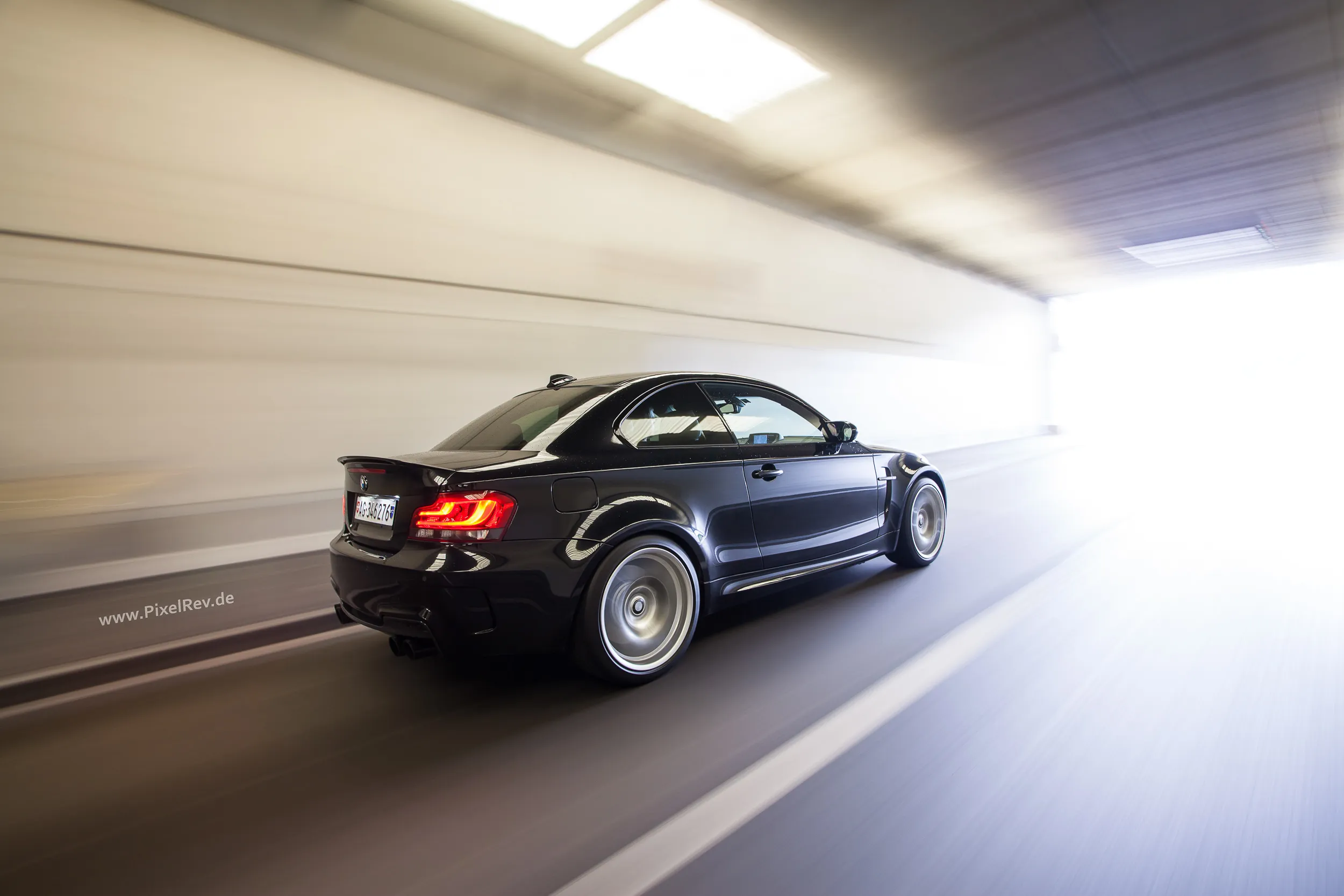 Schwarzes BMW 1M Coupé im Rig Shot in einem hellen Tunnel