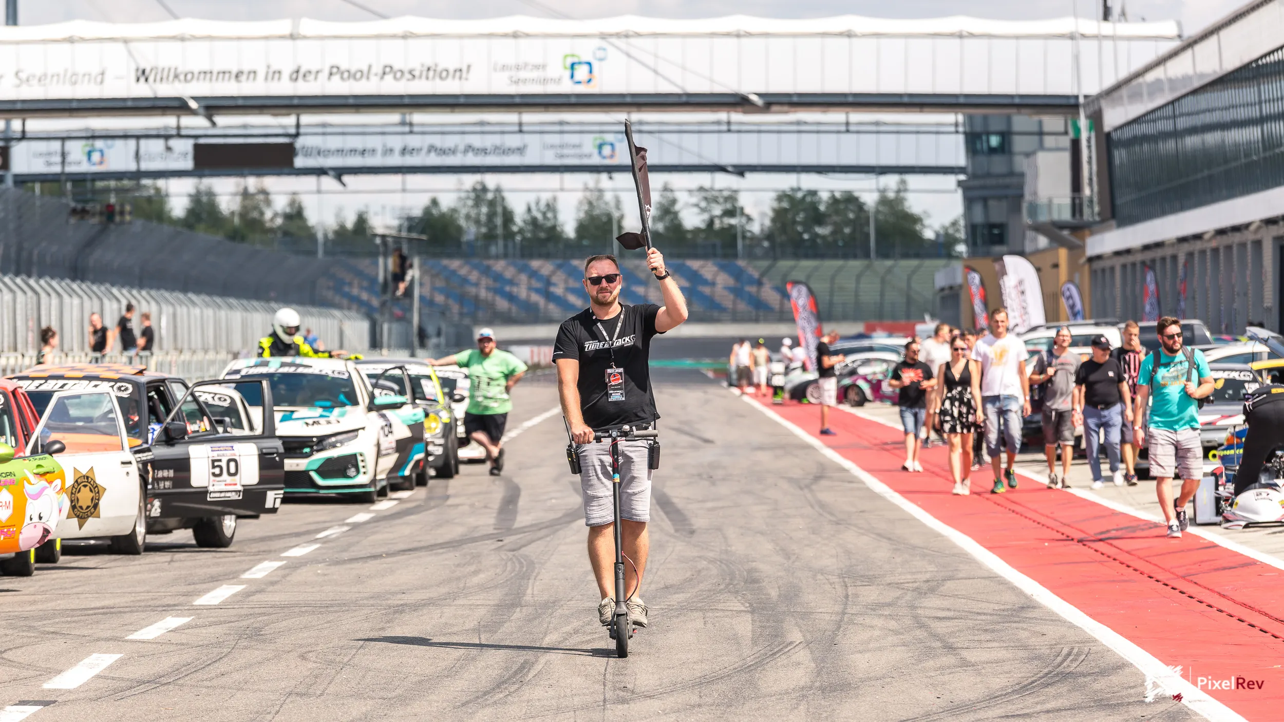 Fahrzeuge und Besucher in der Boxengasse am Lausitzring