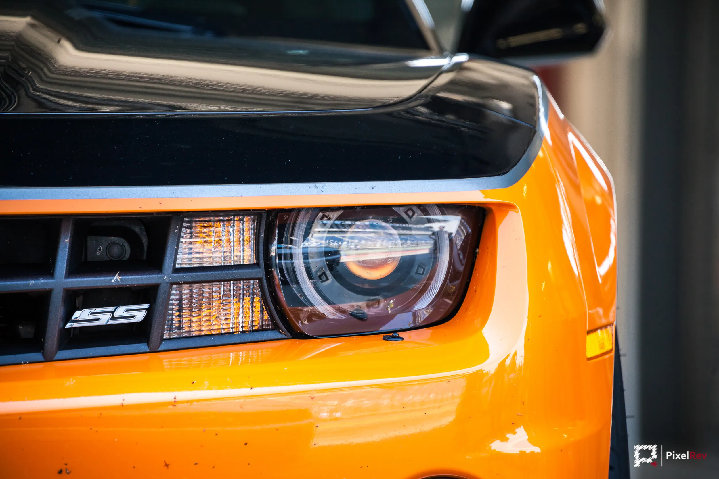 Scheinwerfer eines orangefarbenen Chevrolet Camaro SS, Detailaufnahme