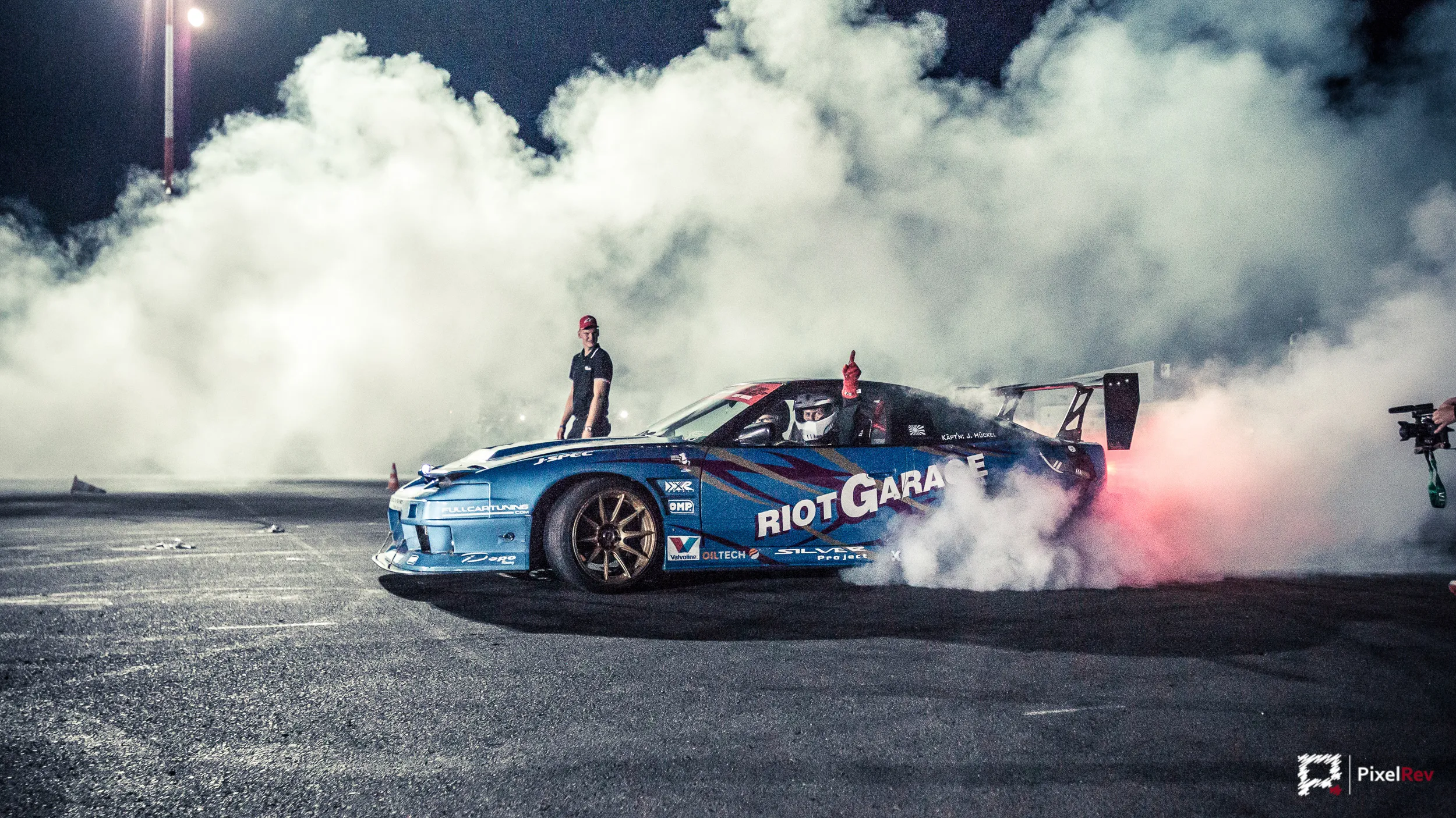 Driftfahrzeug in einer Wolke aus Reifenqualm bei Nacht