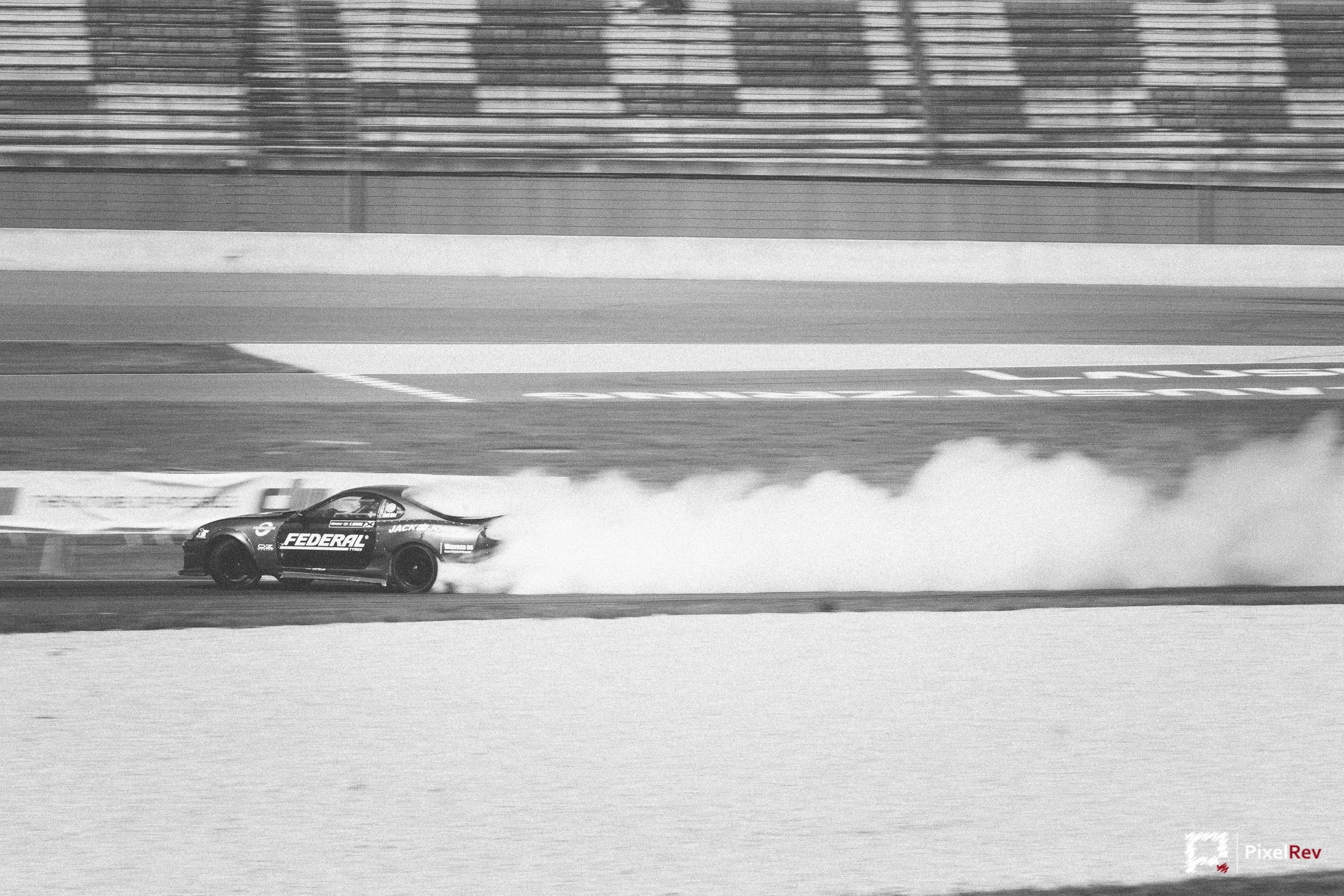 Driftfahrzeug mit langer Reifenqualmfahne, Schwarz-Weiß