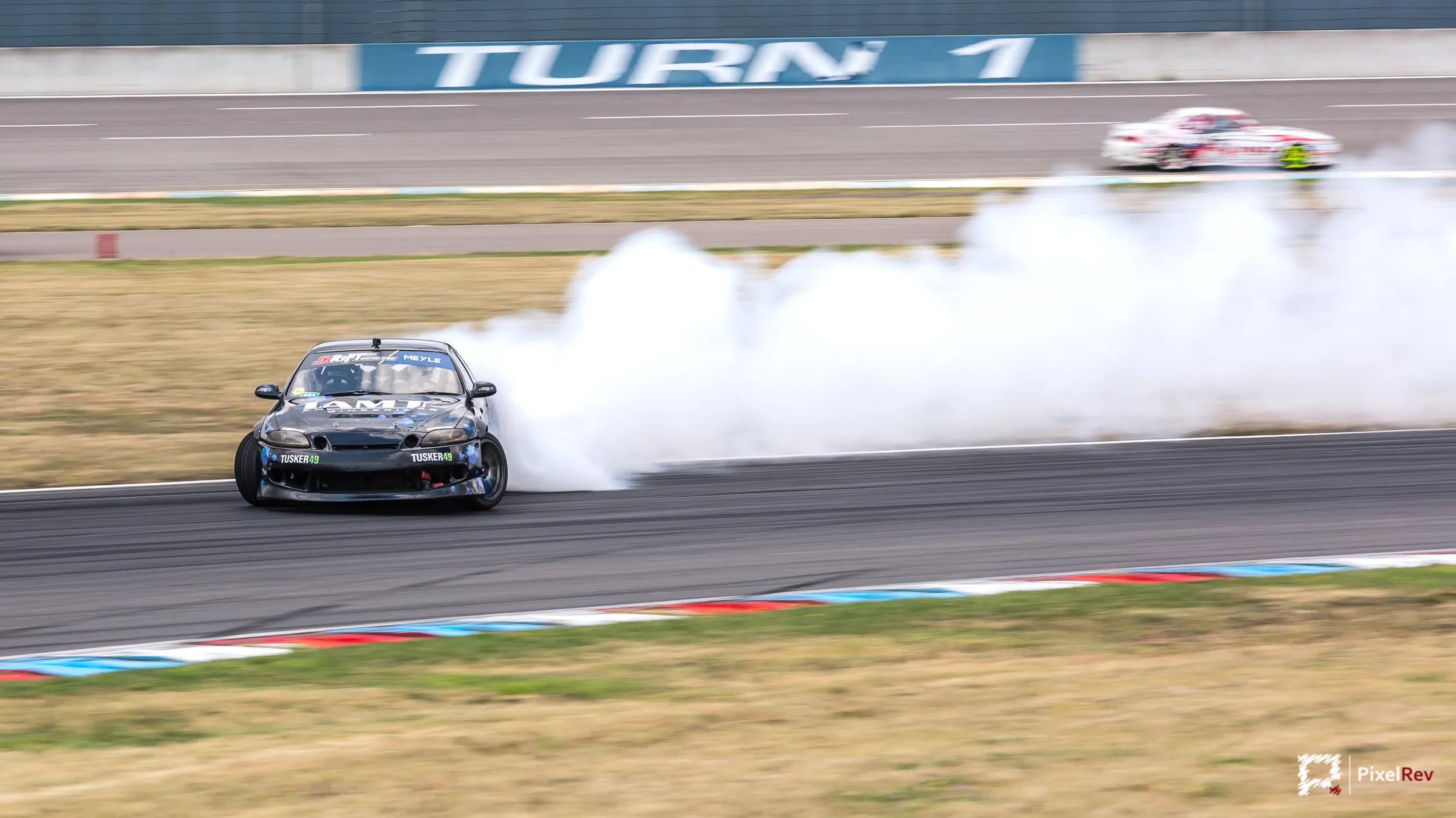 Driftfahrzeug mit Reifenqualm in Turn 1 am Lausitzring