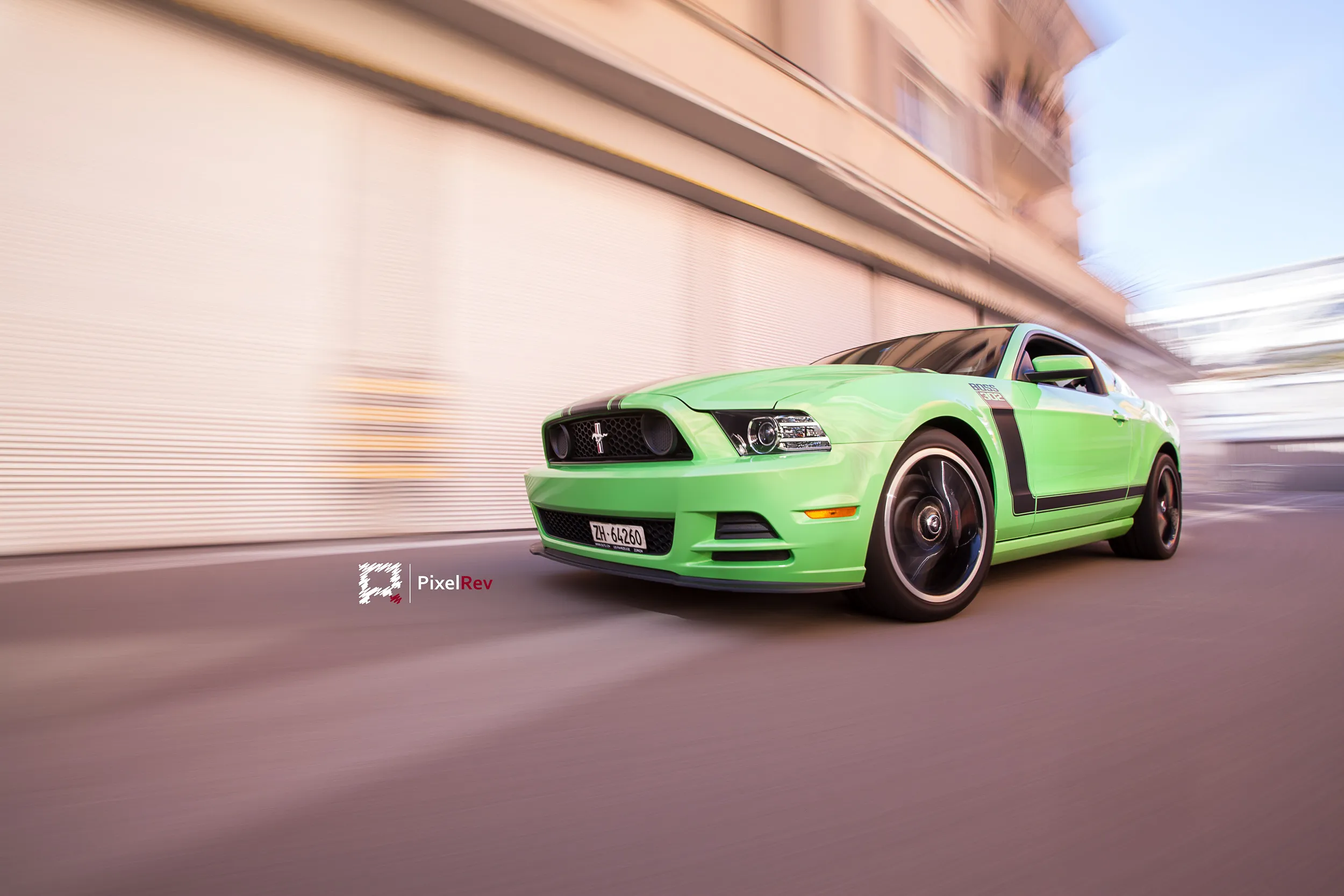 Grüner Ford Mustang Boss 302 im Rig Shot vor einer verwischten Hauswand