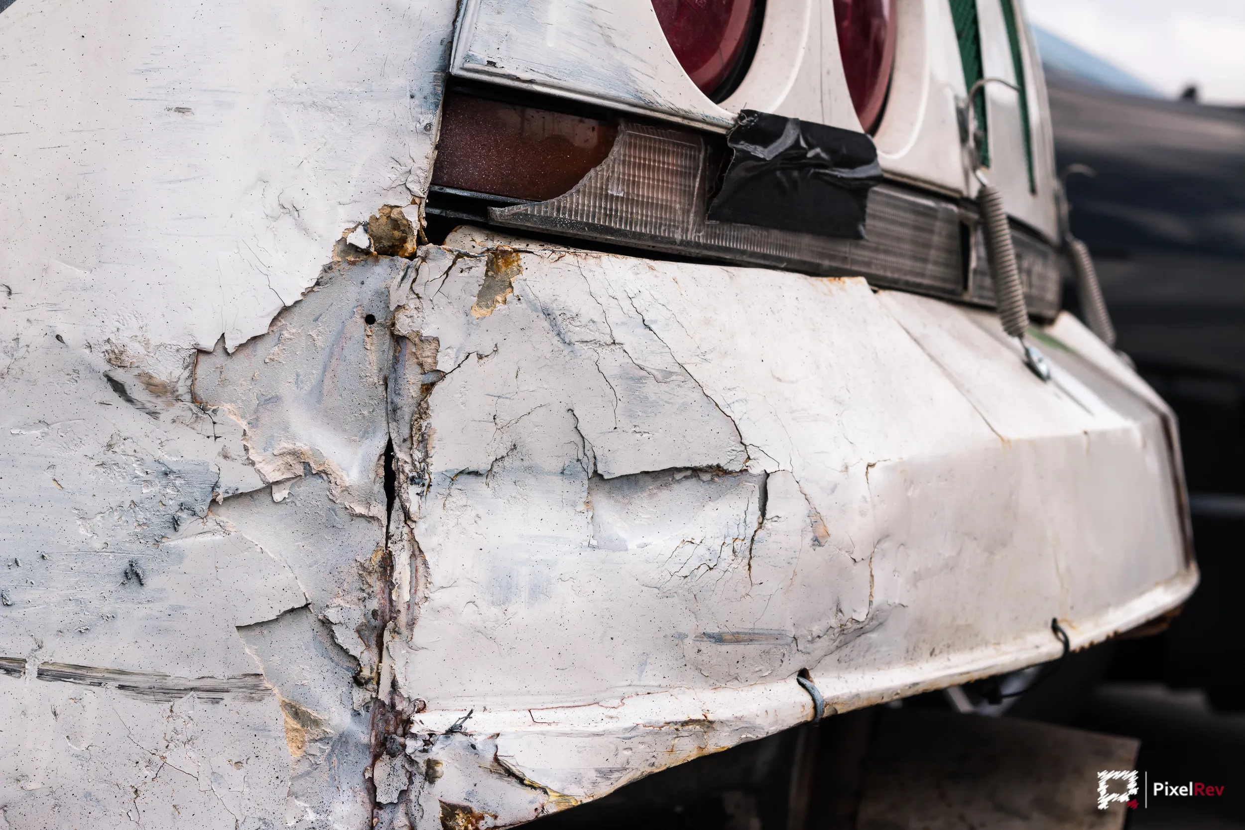 Rissige, notdürftig geflickte Stoßstange eines Driftfahrzeugs, Detailaufnahme