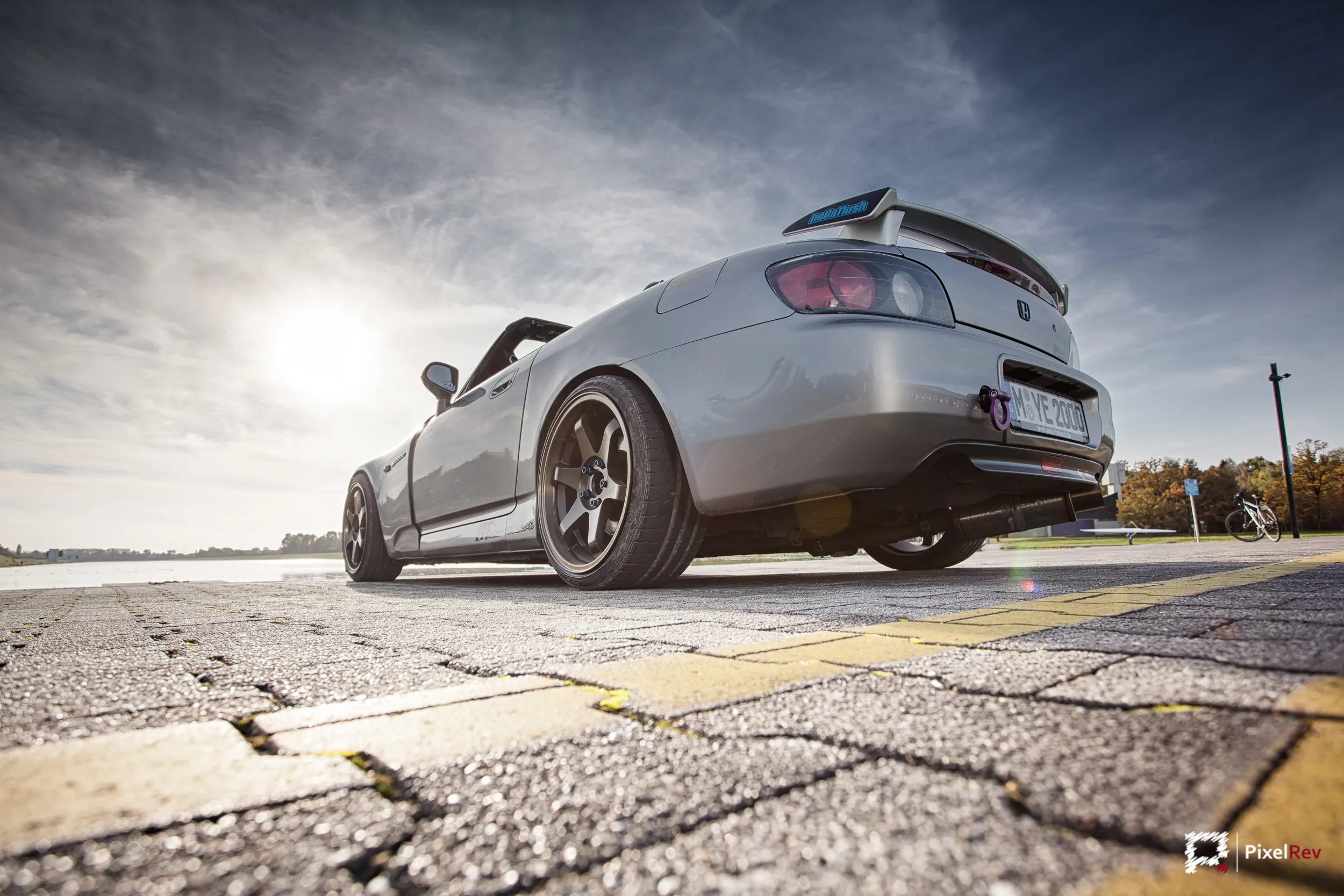 Heck eines silbernen Honda S2000 aus der Froschperspektive im Gegenlicht
