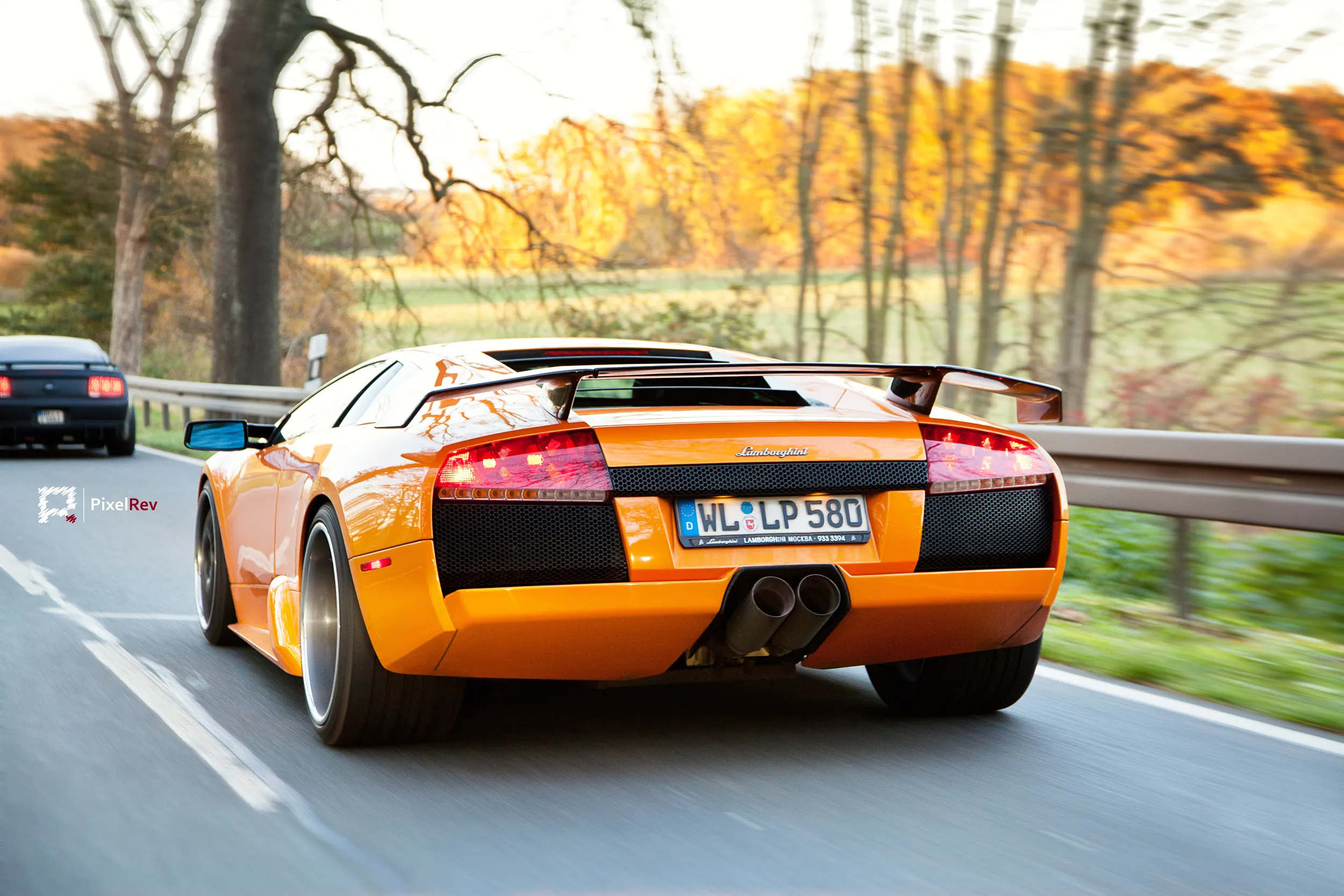 Orangefarbener Lamborghini Murciélago in Fahrt auf der Landstraße, Heckansicht