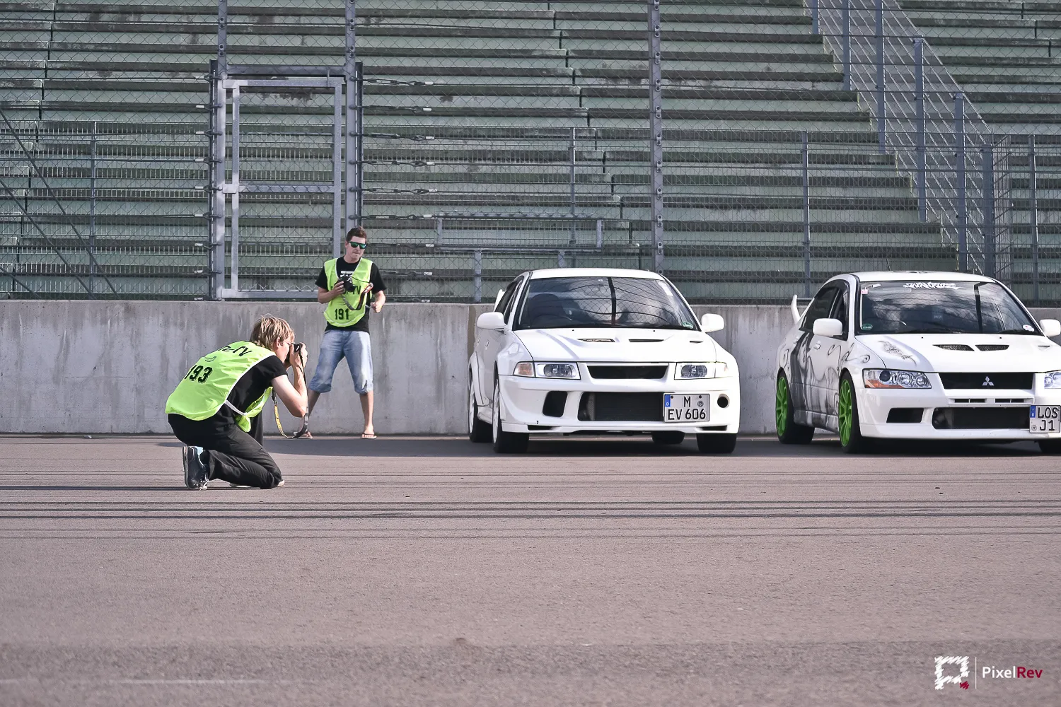 Fotograf kniet vor zwei weißen Mitsubishi Lancer Evolution