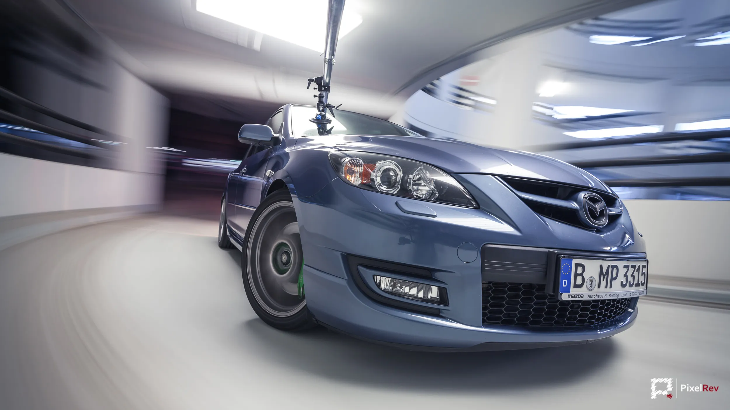 Front eines blauen Mazda 3 MPS im Rig Shot, Parkhaus in Bewegungsunschärfe