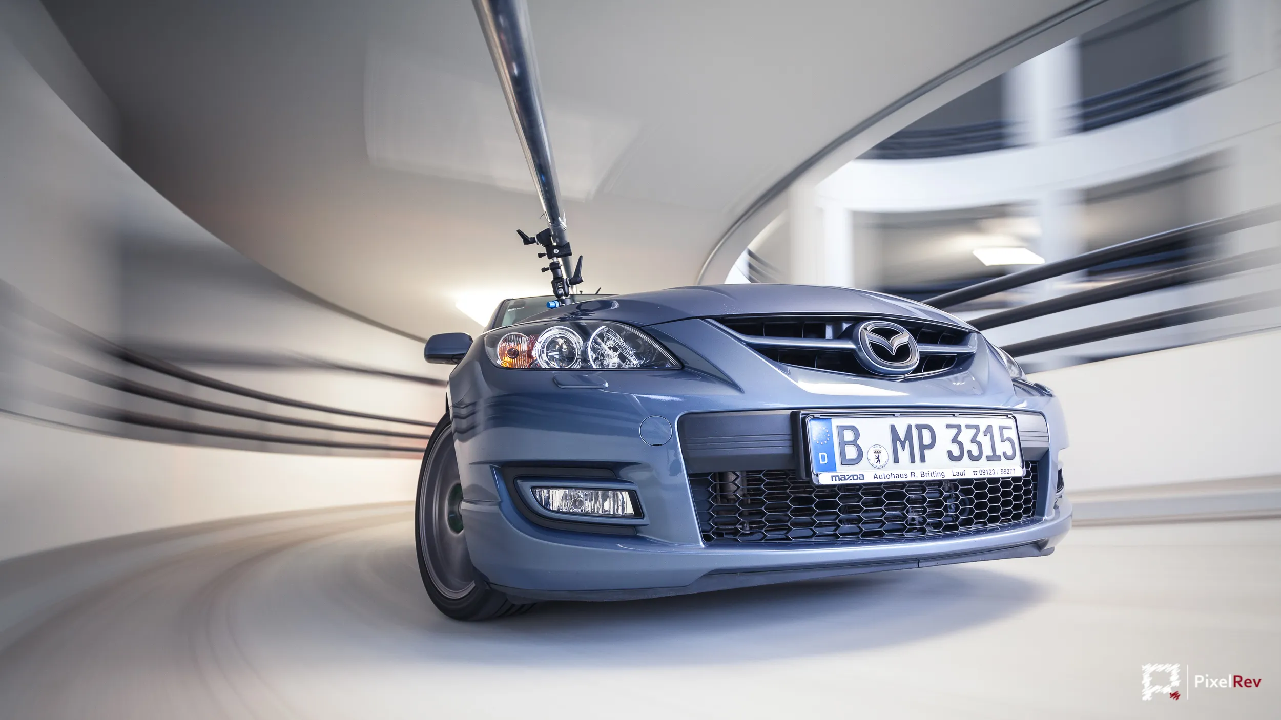 Blauer Mazda 3 MPS im Rig Shot auf einer Parkhausrampe