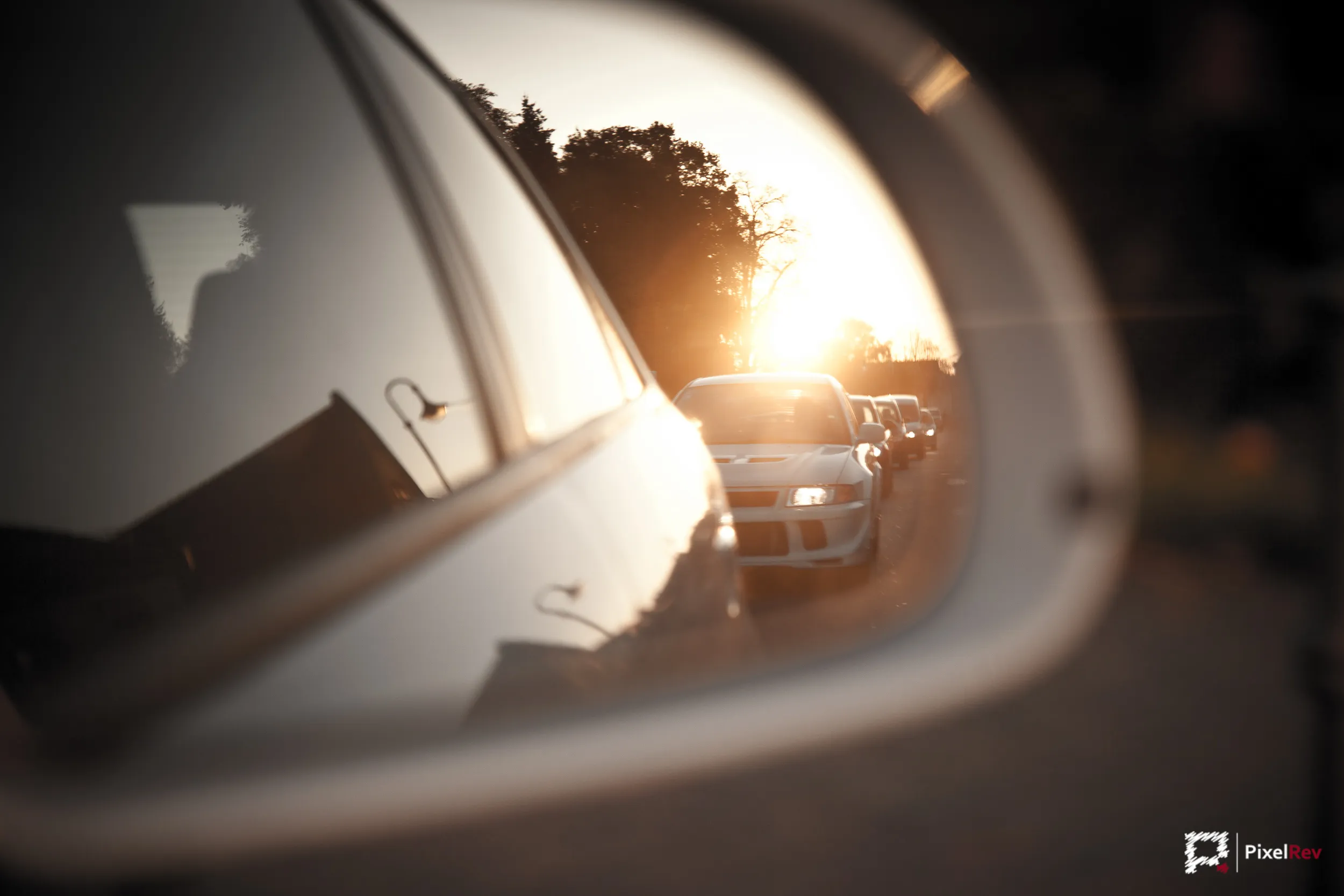 Mitsubishi Lancer Evolution VI im Außenspiegel bei Sonnenuntergang