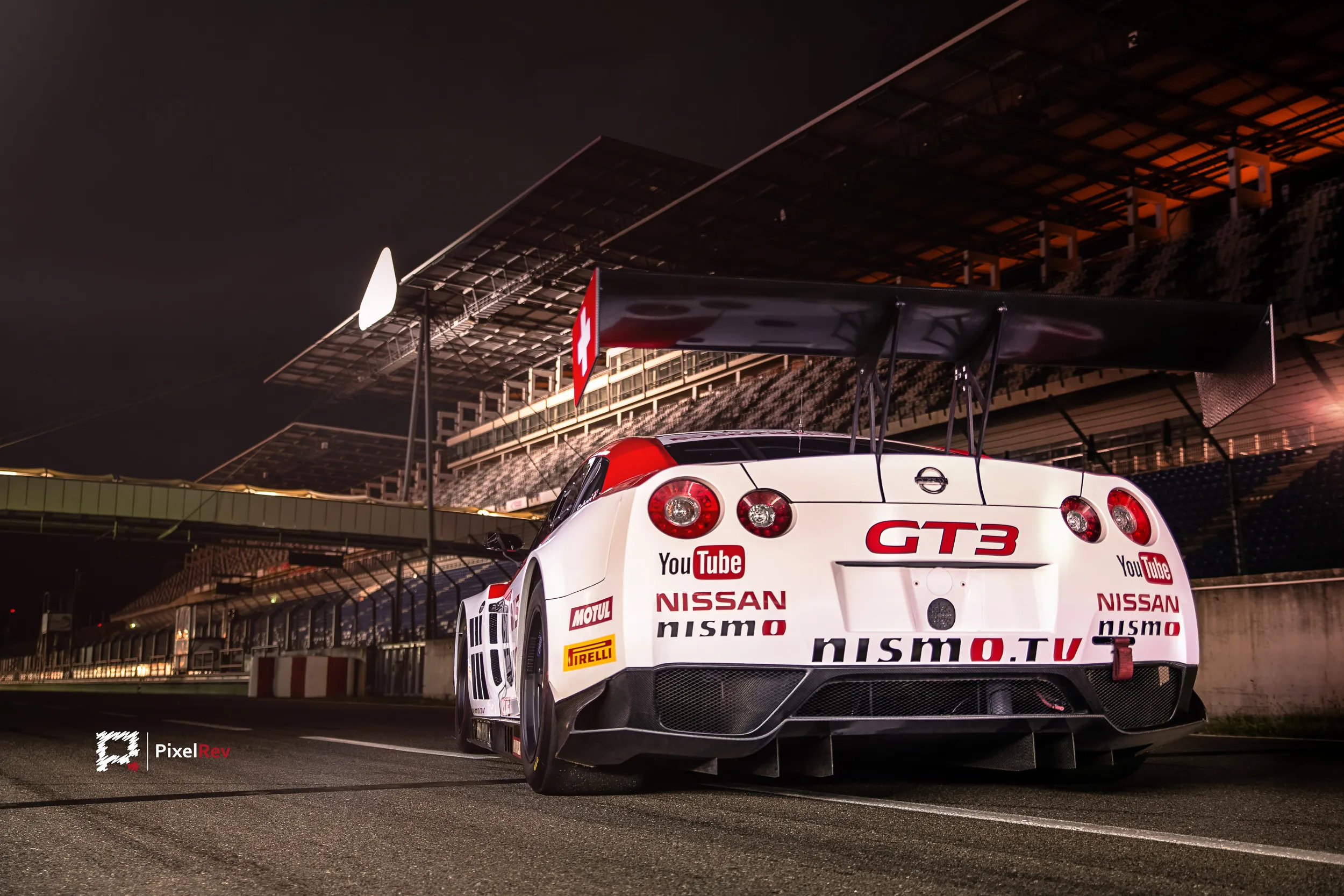 Heck des Nissan GT-R Nismo GT3 mit Heckflügel nachts vor der Tribüne