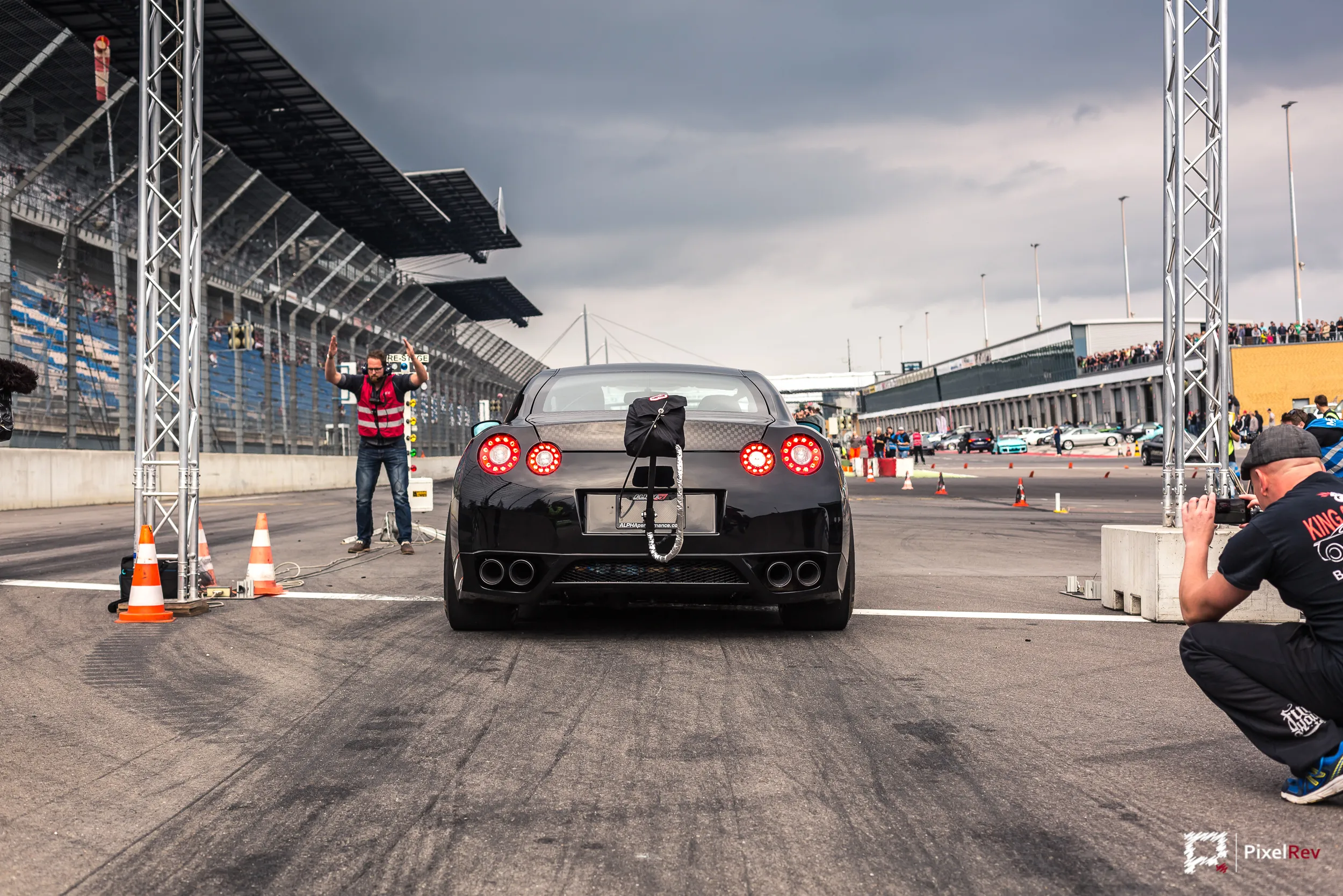 Schwarzer Nissan GT-R am Start der Viertelmeile, Fotograf am Rand