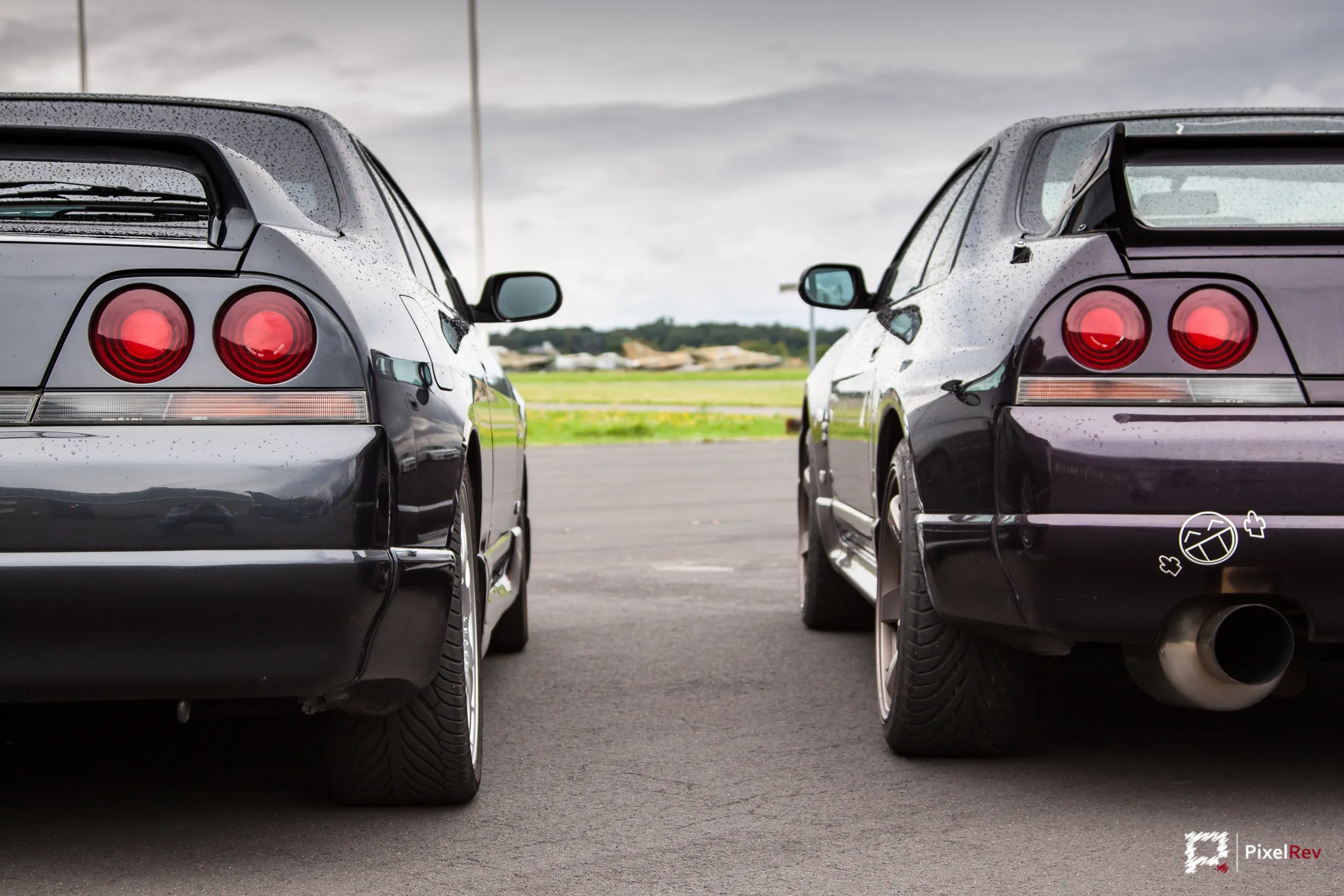 Hecks zweier dunkler Nissan Skyline R33 nebeneinander