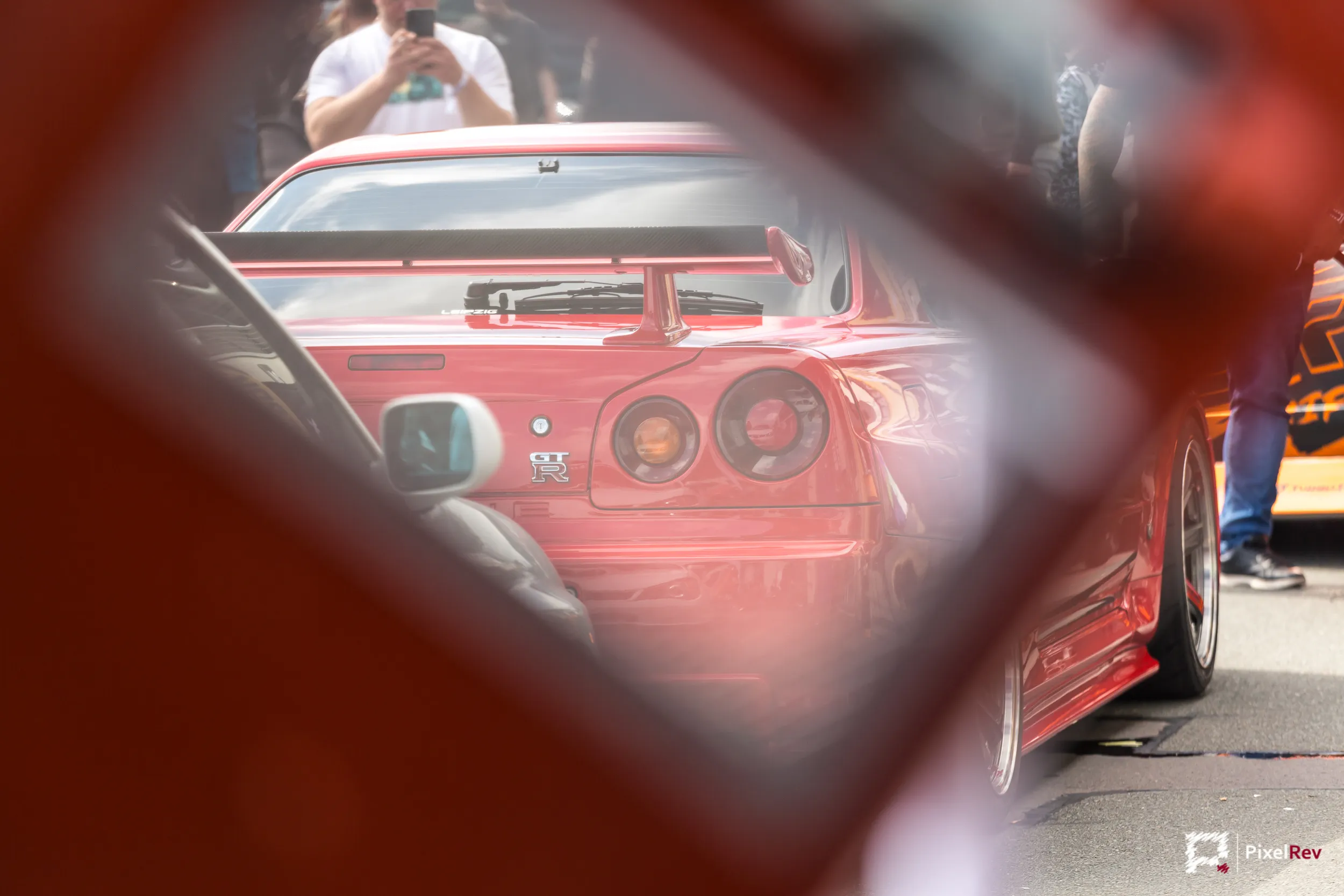 Roter Nissan Skyline R34 GT-R, durch eine Öffnung fotografiert
