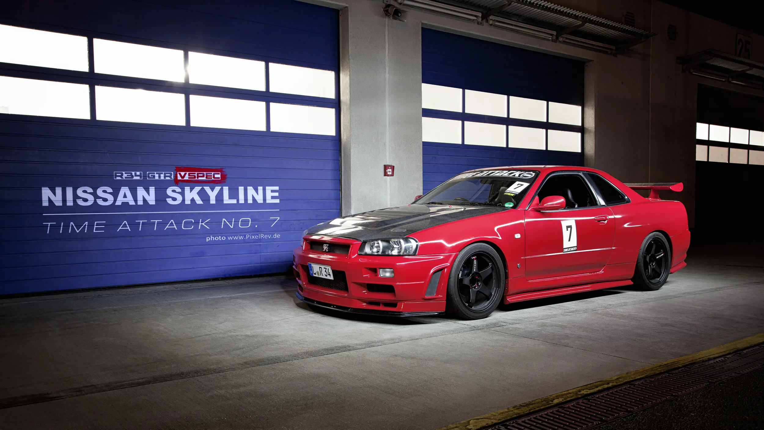 Roter Nissan Skyline R34 GT-R in der Box mit dem Titel „Time Attack No. 7“