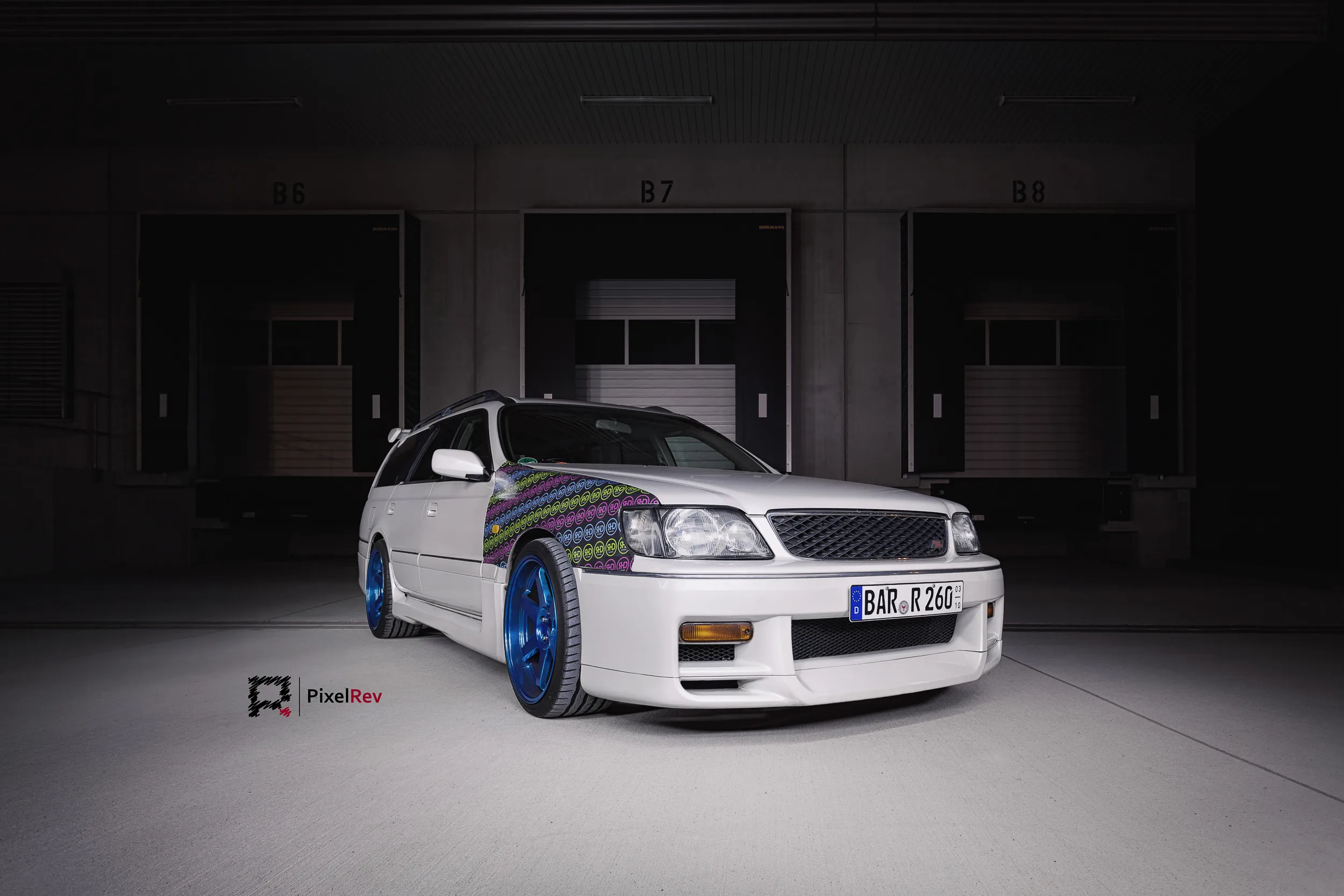 Front des Nissan Stagea mit bunter Folierung vor Ladetoren
