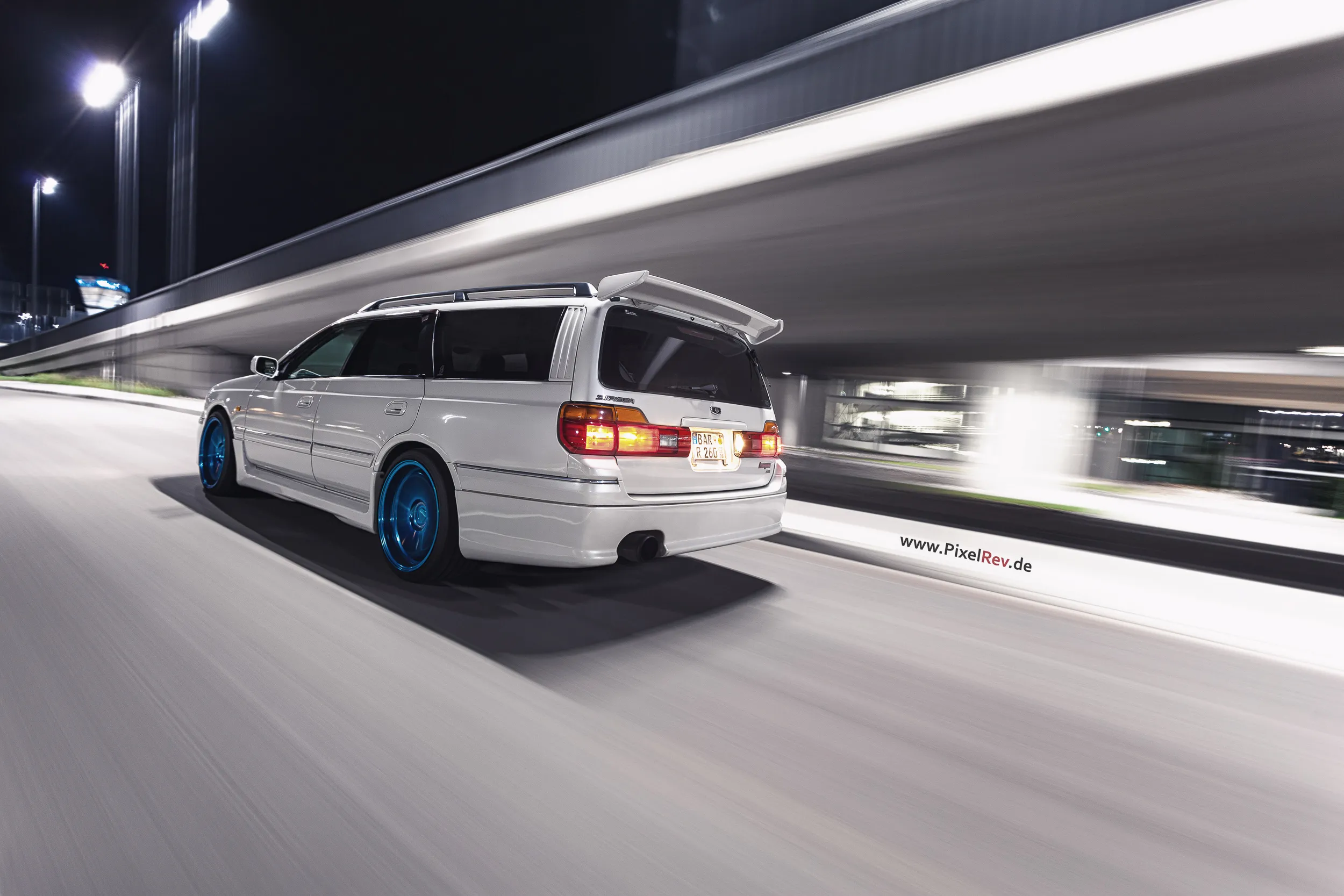 Weißer Nissan Stagea von hinten im Rig Shot, Bremslichter leuchten
