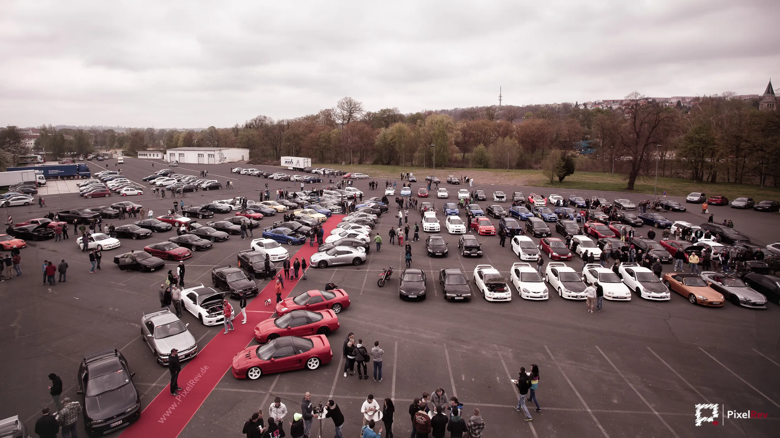 Blick über einen Parkplatz voller Tuningfahrzeuge beim Überfest 2013 in Döbeln
