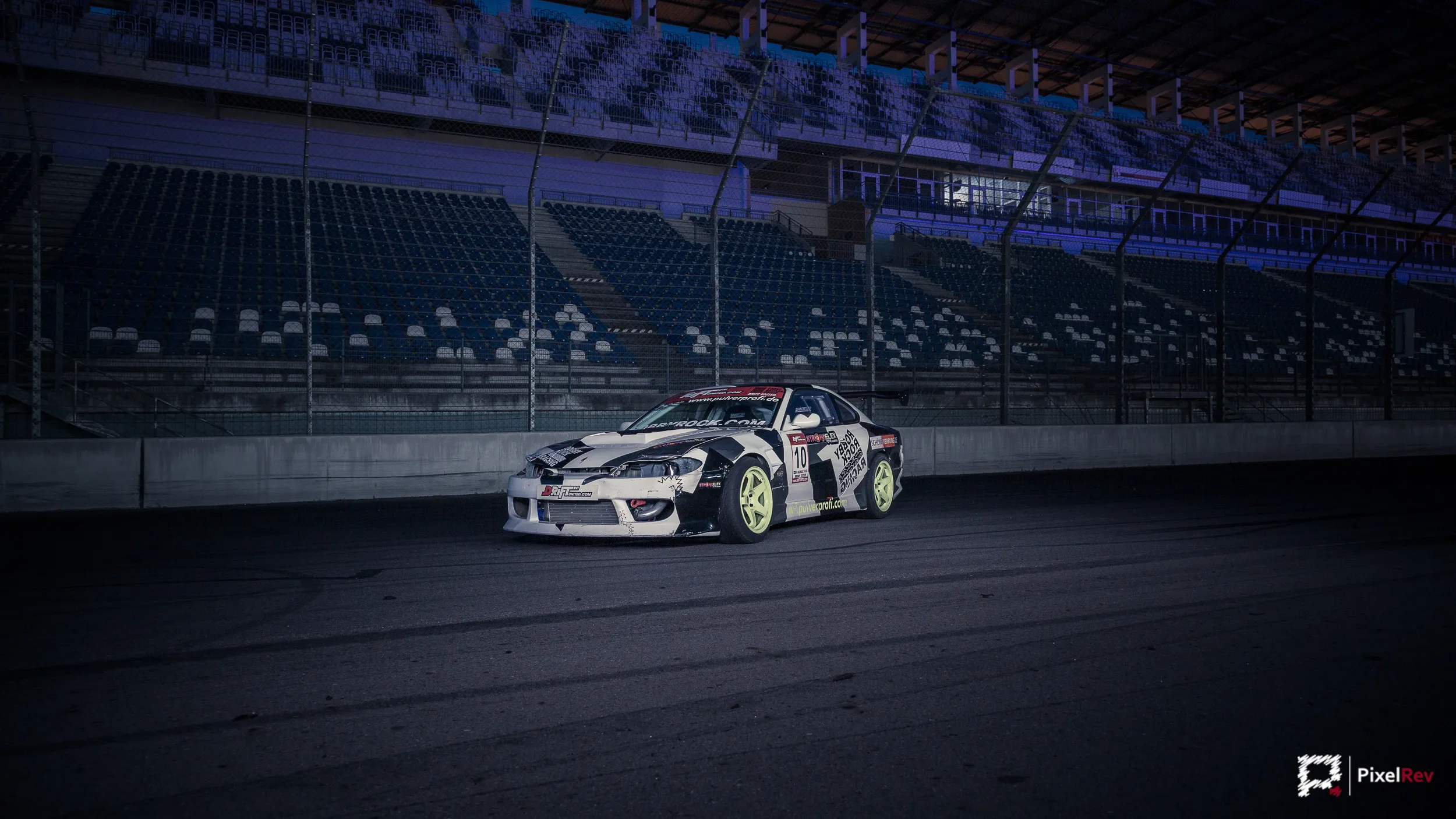 Driftfahrzeug von Robby Rock Racing in der Seitenansicht vor der beleuchteten Tribüne