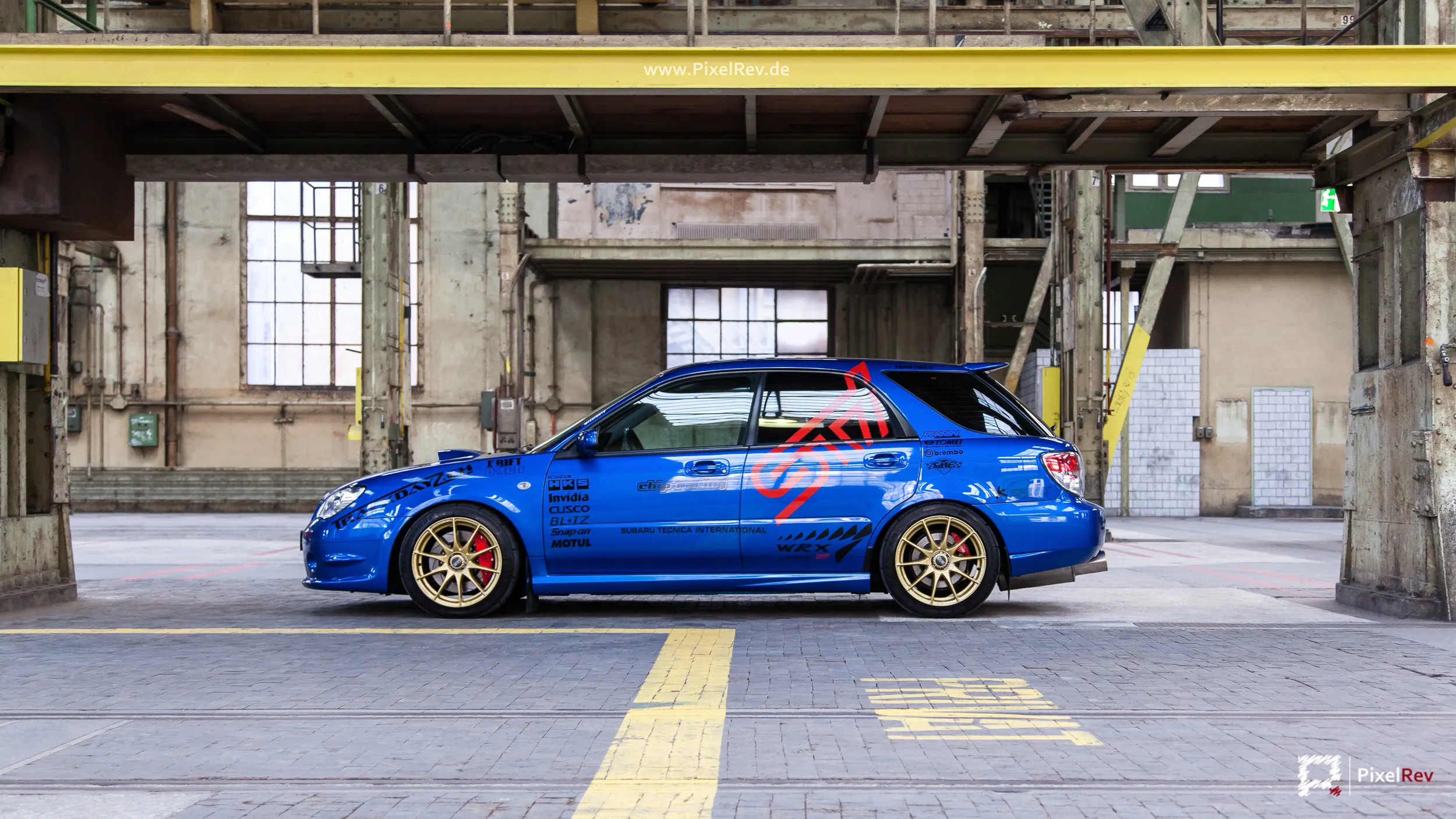 Blauer Subaru Impreza WRX STI in der Seitenansicht in einer Industriehalle