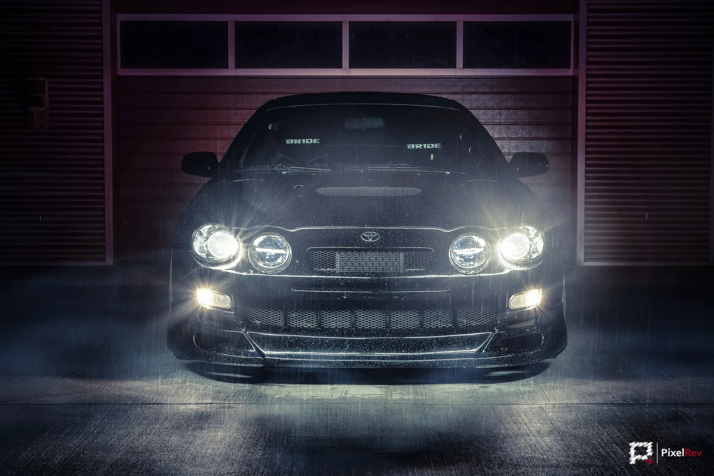 Front der schwarzen Toyota Celica GT-Four mit eingeschalteten Scheinwerfern bei Nacht