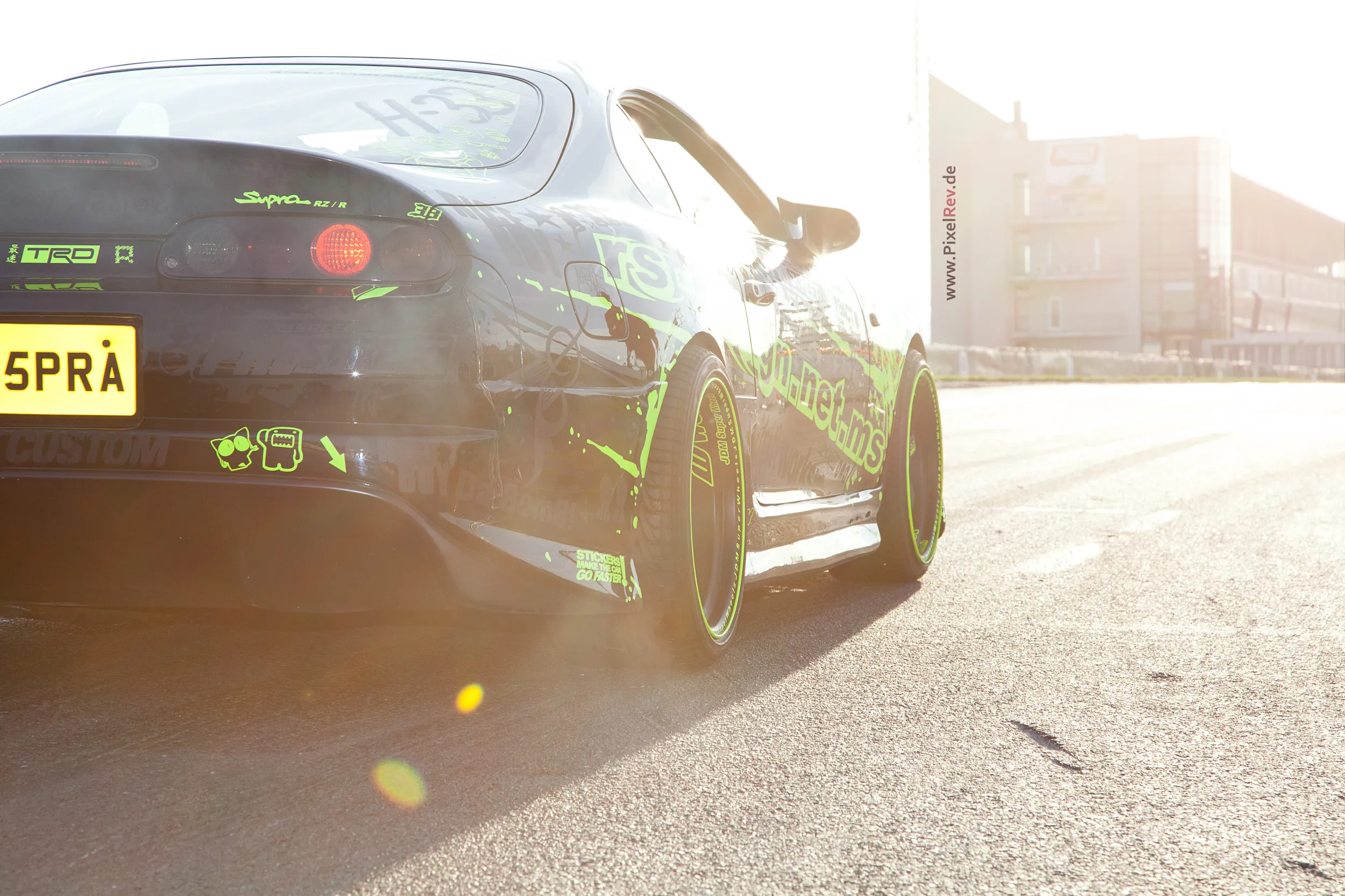 Schwarzer Toyota Supra mit grüner Folierung im Gegenlicht beim Reisbrennen 2012