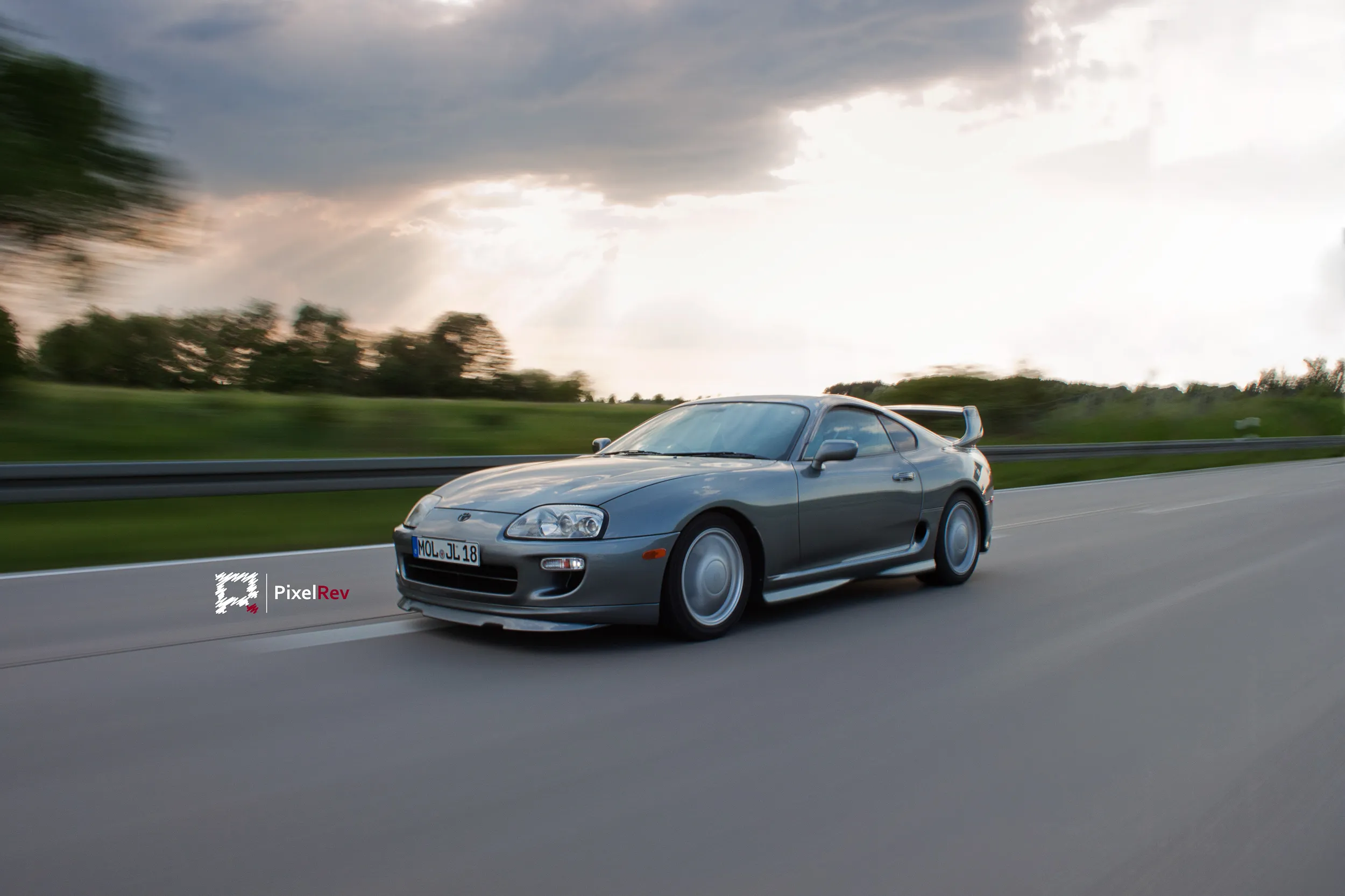 Silberner Toyota Supra Mk4 in Fahrt auf einer Landstraße