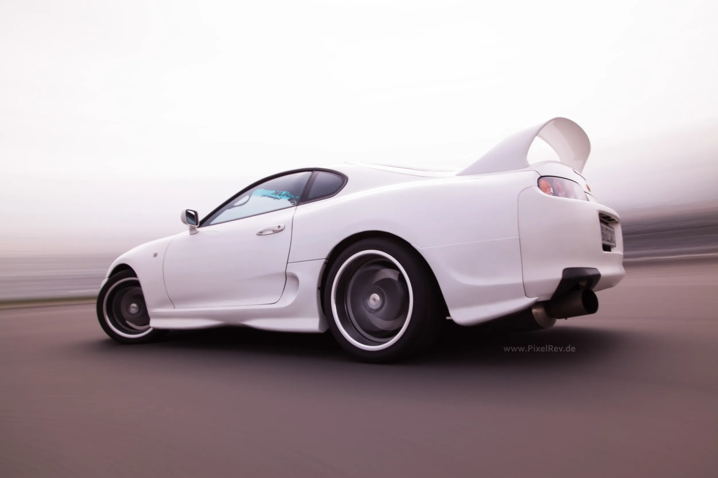 Weißer Toyota Supra im Rig Shot, Umgebung in Bewegungsunschärfe
