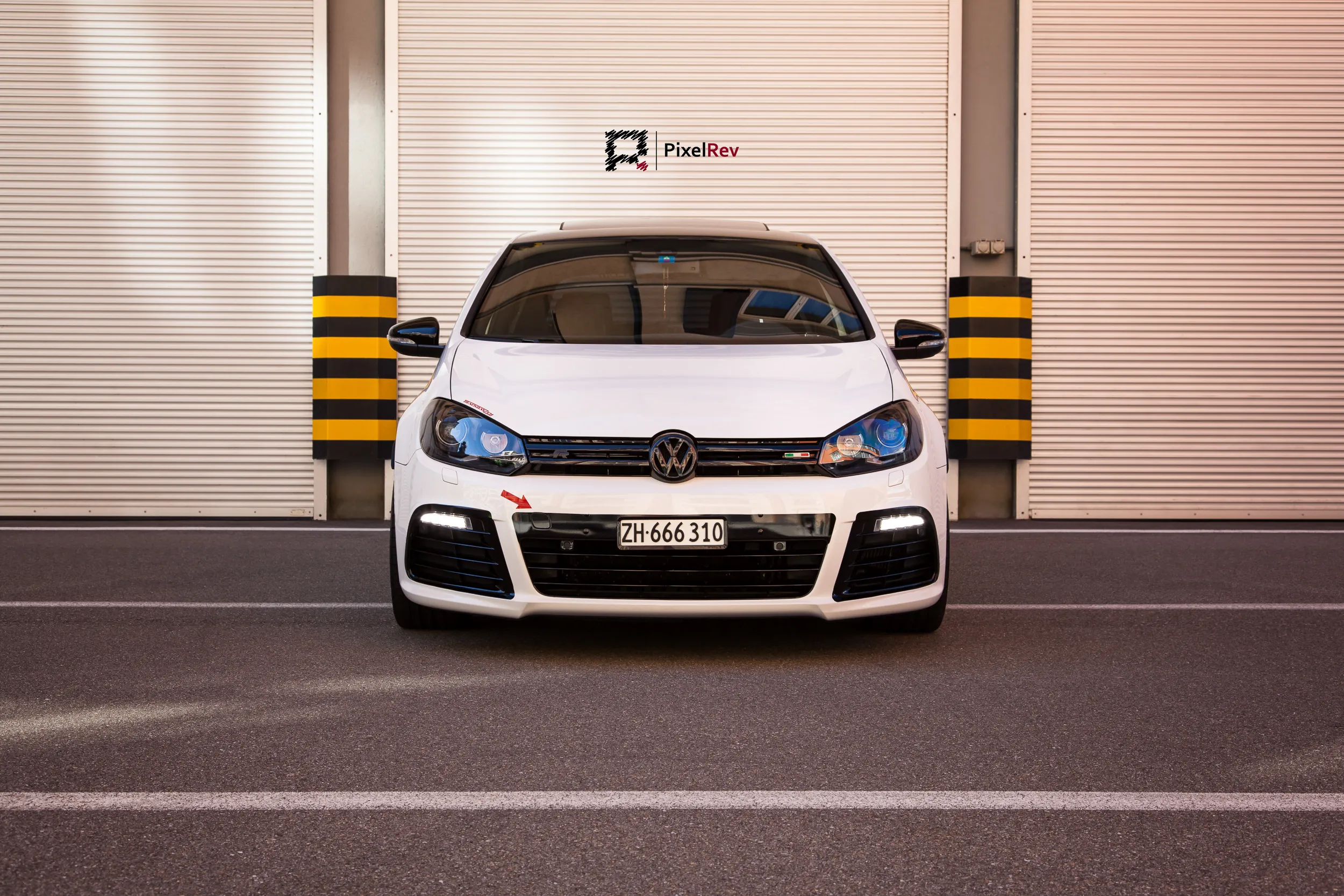 Front eines weißen VW Golf R vor einem Rolltor