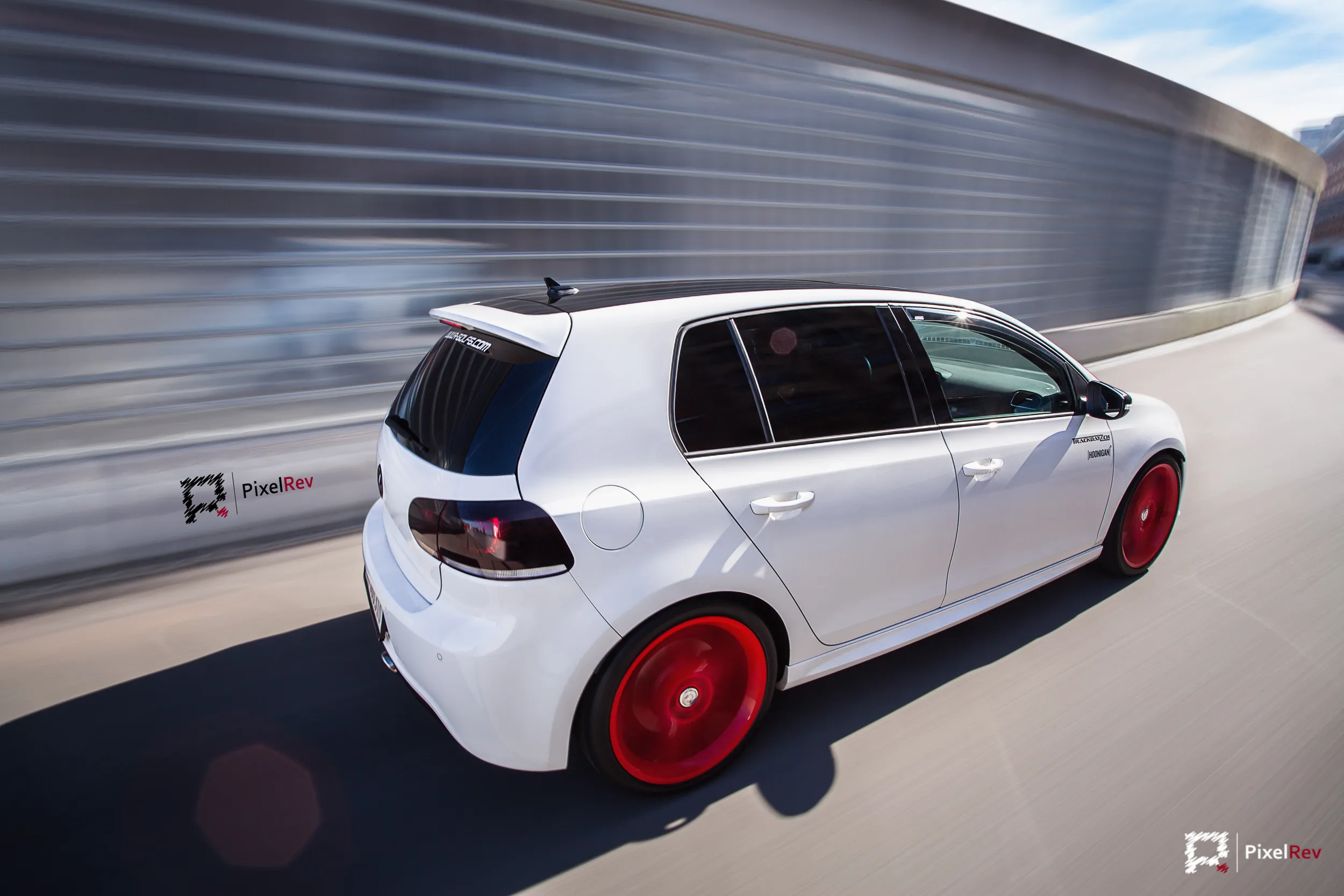 Weißer VW Golf R mit roten Felgen im Rig Shot, Umgebung in Bewegungsunschärfe